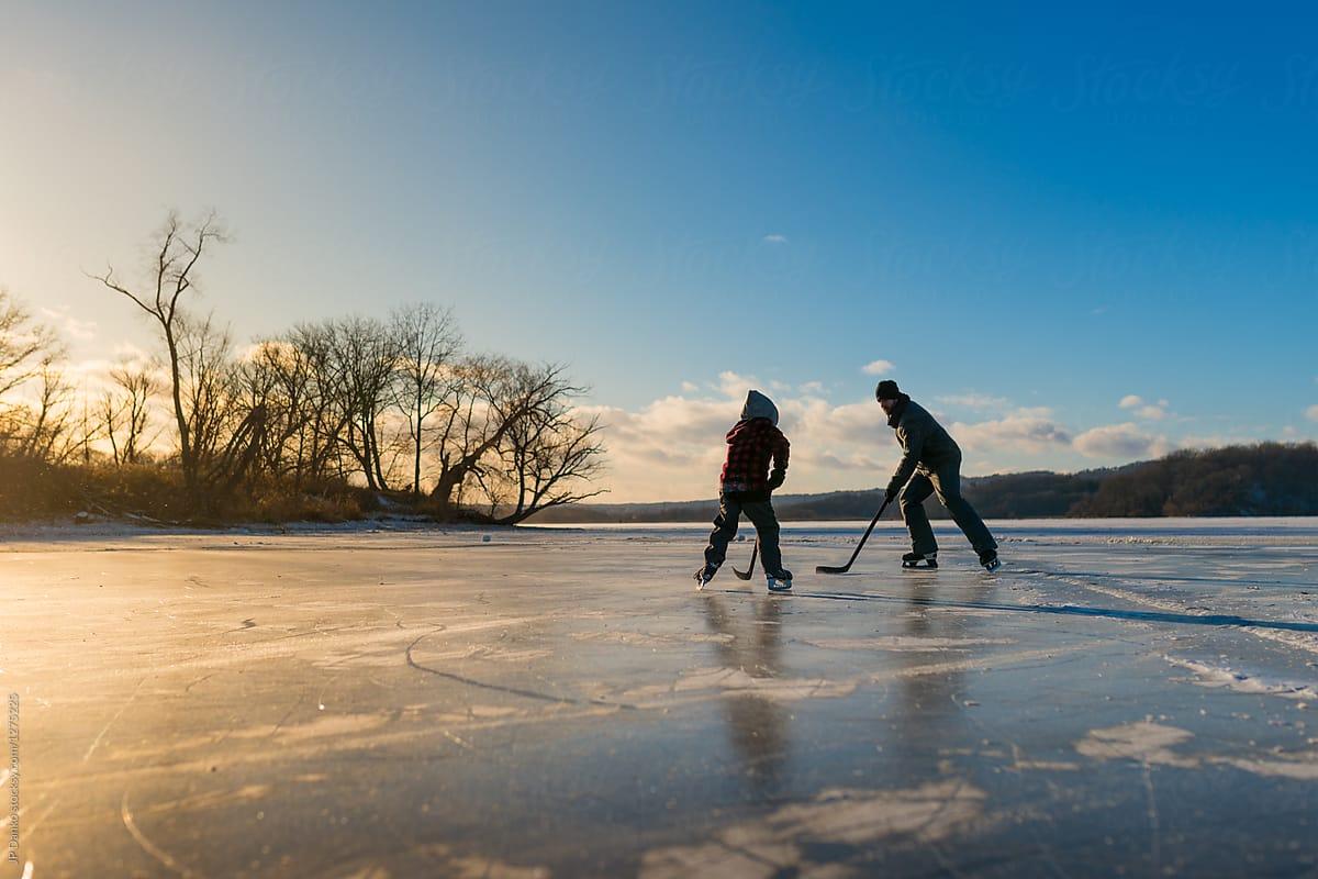 1200x800 Man And Boy Skating Playing Ice Hockey On Outdoor Frozen Pond In Winter by JP Danko, Ice Hockey
