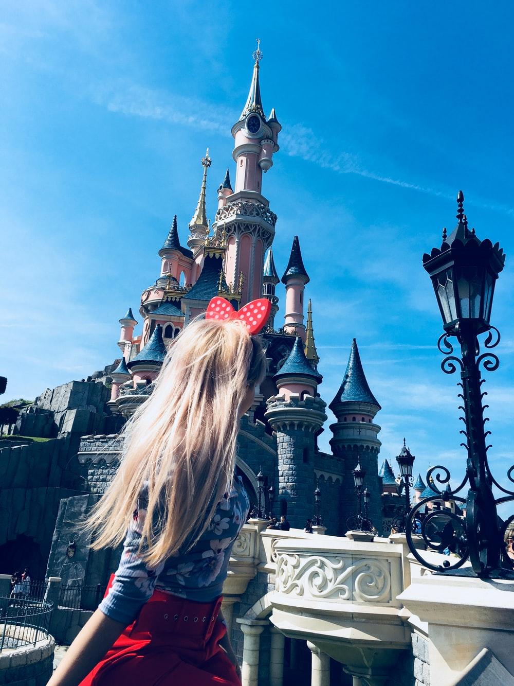1000x1333 girl wearing red alice band looking at cinderella castle photo