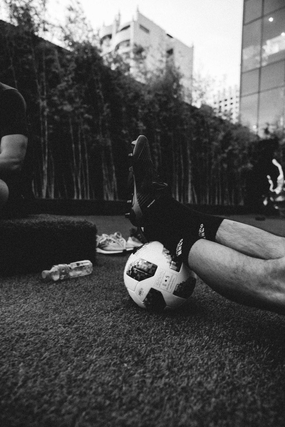 1000x1497 gray scale photo of a person's feet on a football photo