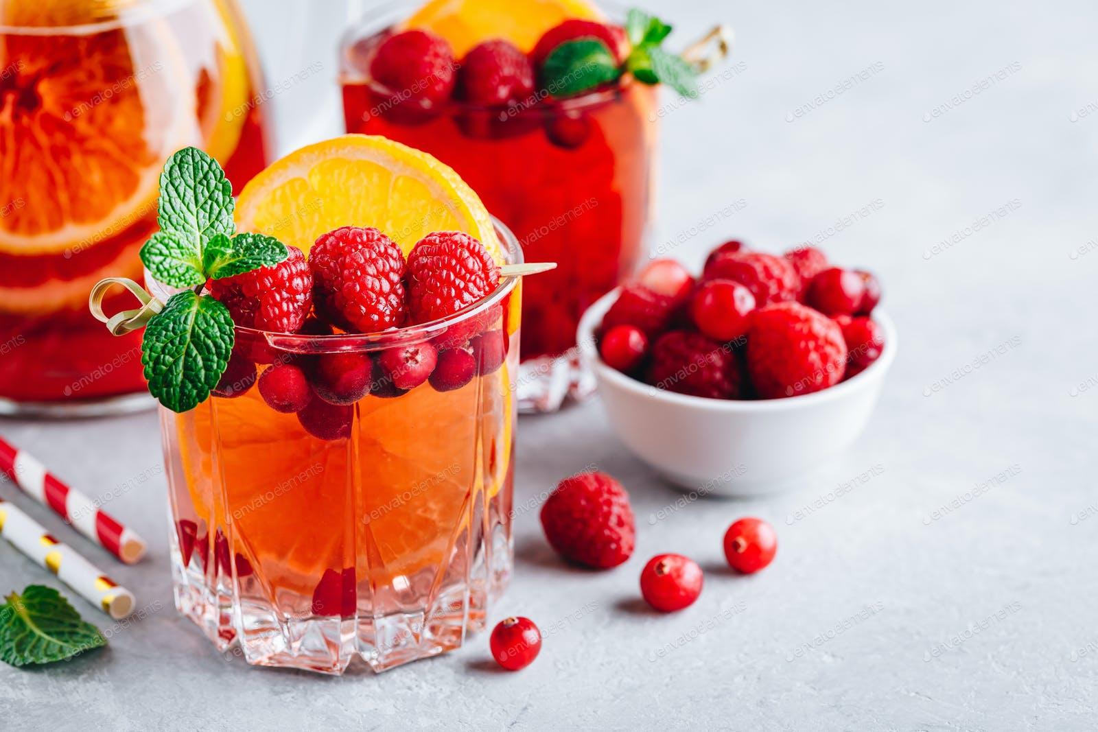 1600x1067 Raspberry Cranberry Sangria Punch or Mojito in glass with orange slices and mint photo by nblxer on Envato Elements