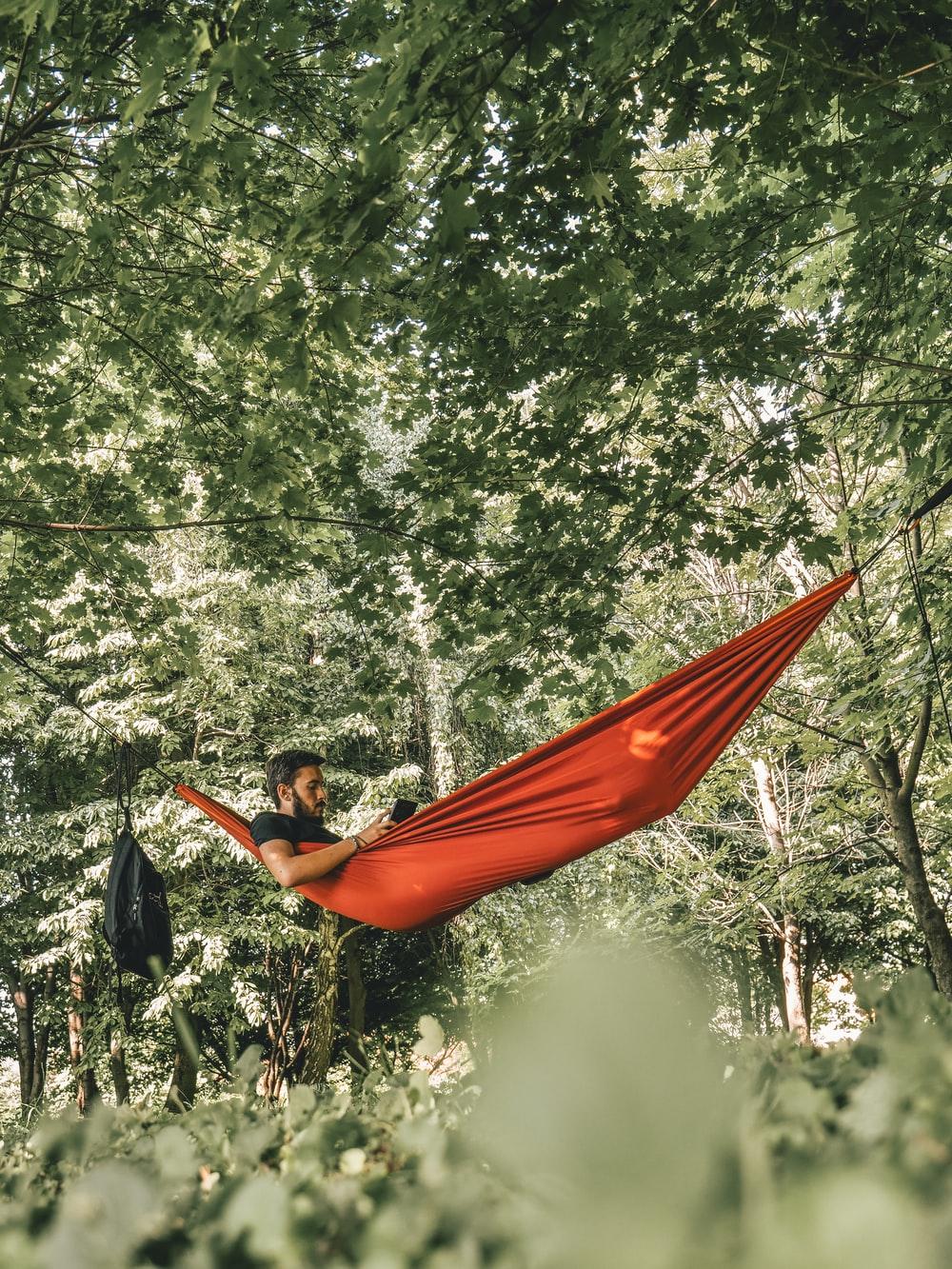 1000x1333 man on red hammock surrounded by trees during daytime photo