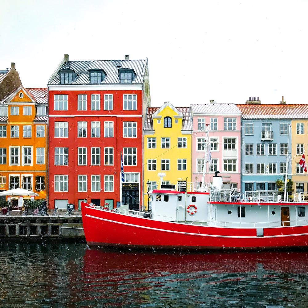 1000x1000 Assorted Color Buildings Near Red Boat Docked On Port During Daytime Photo