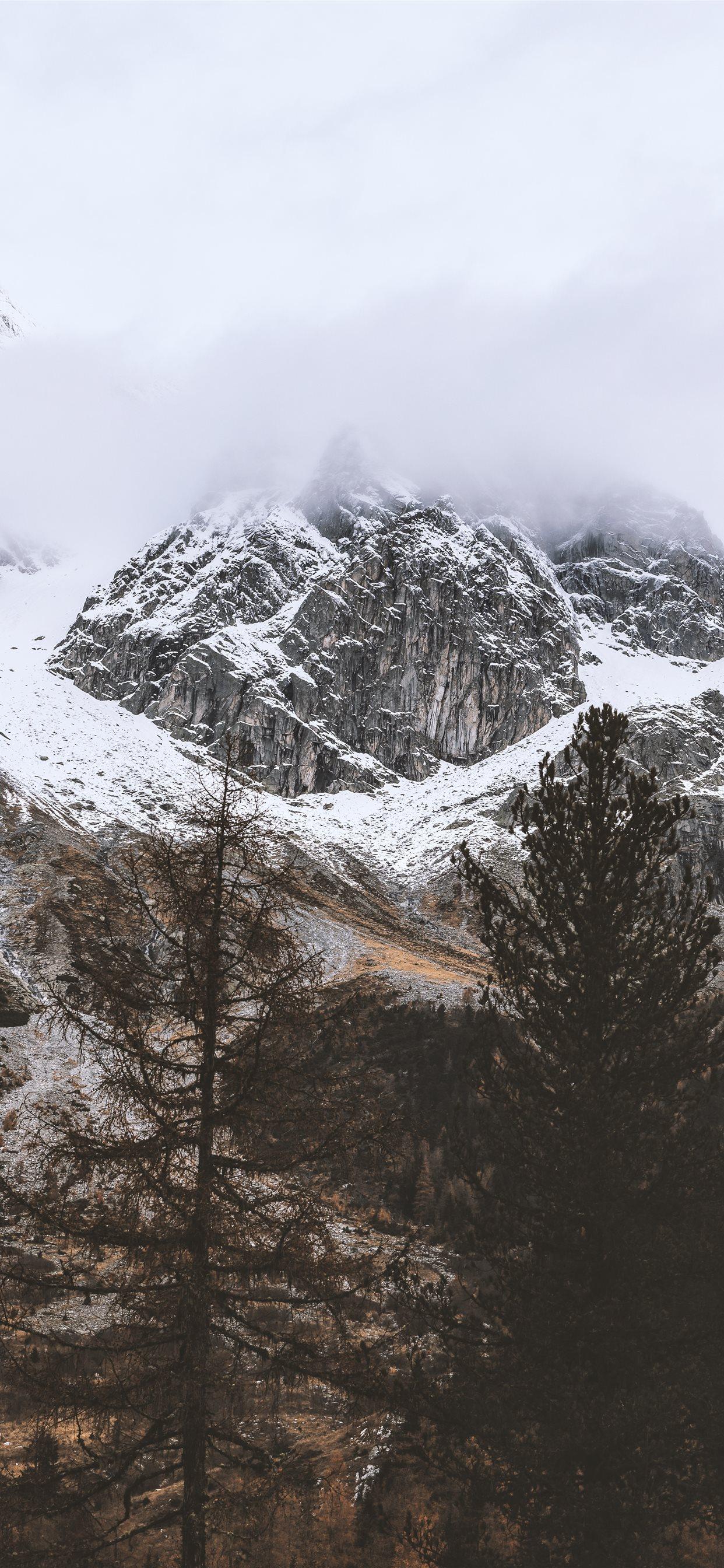 1242x2688 snow capped rocky mountain under cloudy sky iPhone X Wallpaper Free Download
