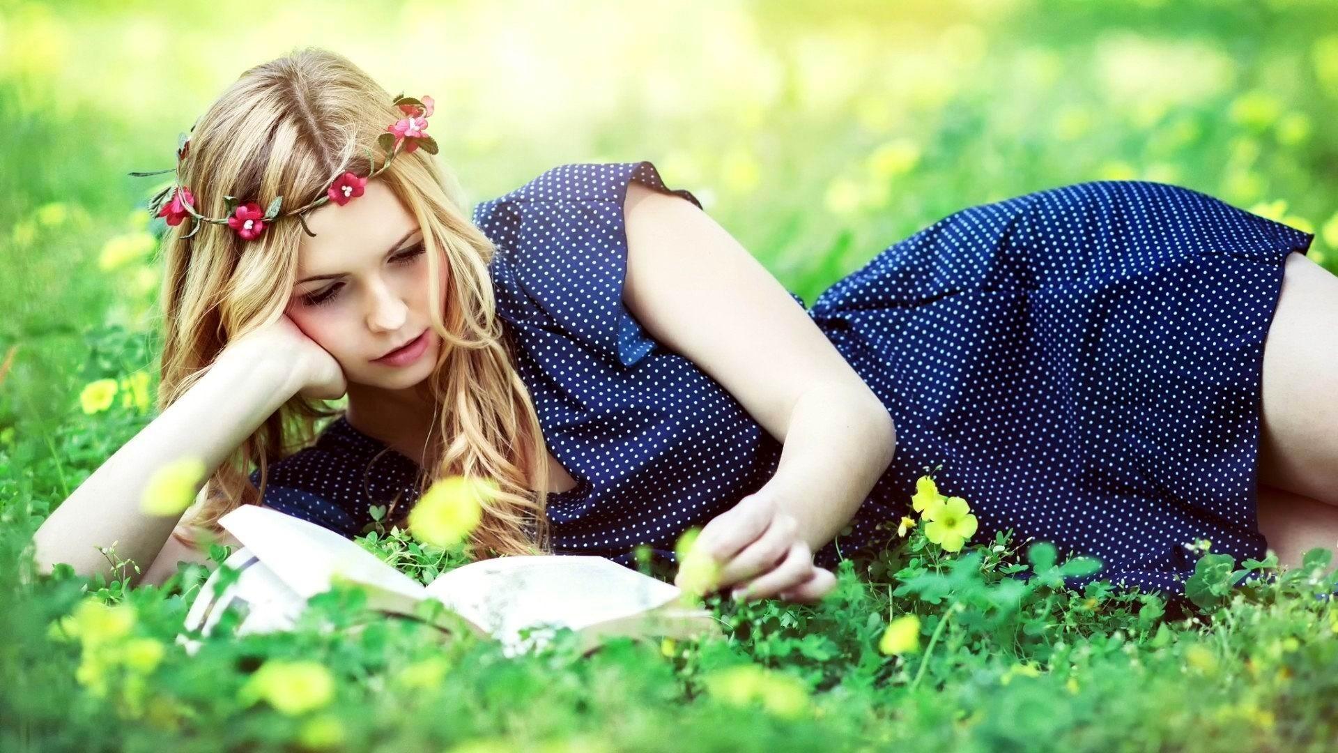 1920x1080 #polka dots, #lying on front, #blue dress, #women outdoors, #women, #flower in hair, #reading, #books, #blonde, #dress, #flowers, #model, #long hair, #grass, wallpaper HD Wallpaper