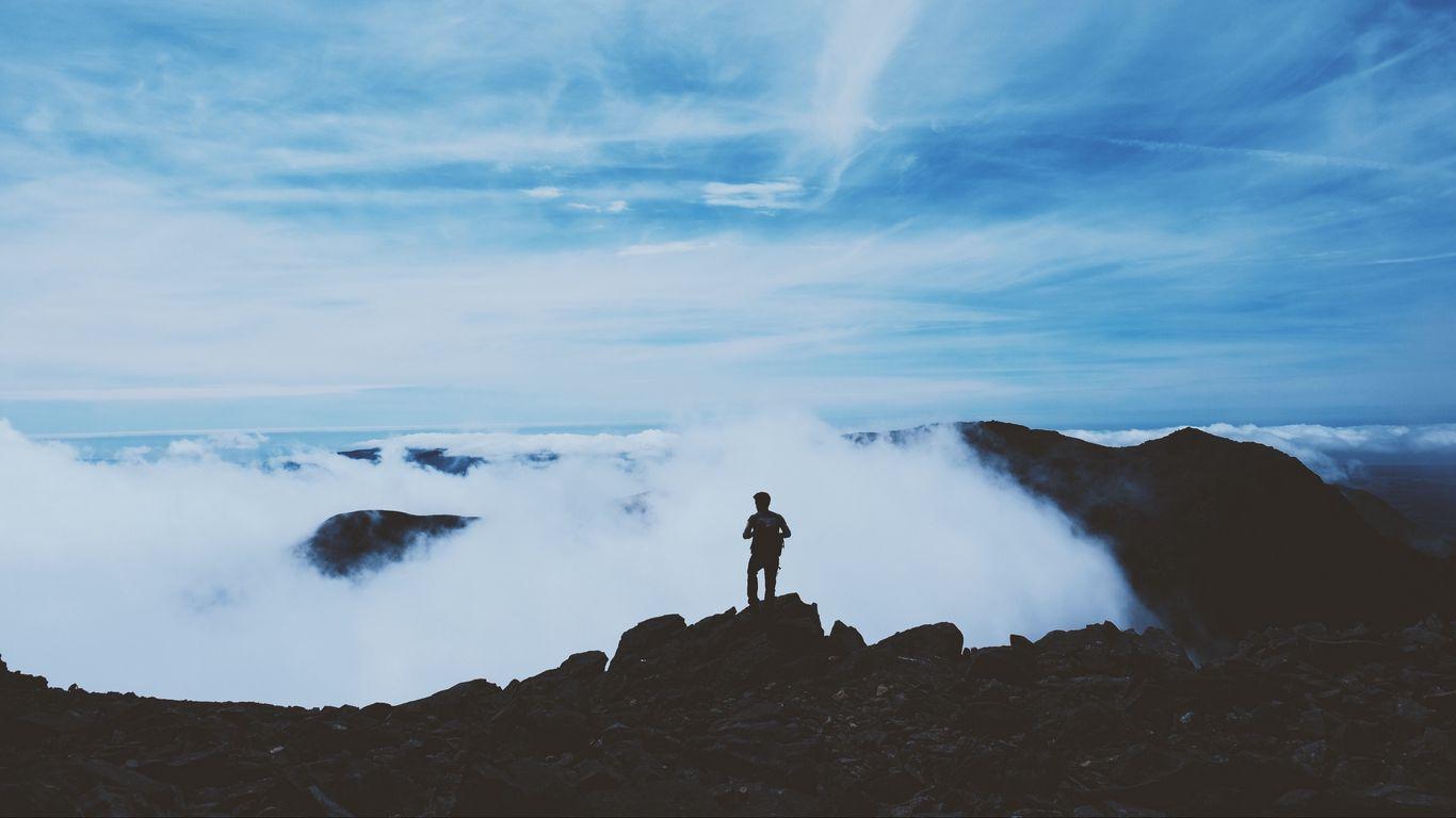1366x768 Download wallpaper 1366x768 man, silhouette, mountains, clouds, top tablet, laptop HD background