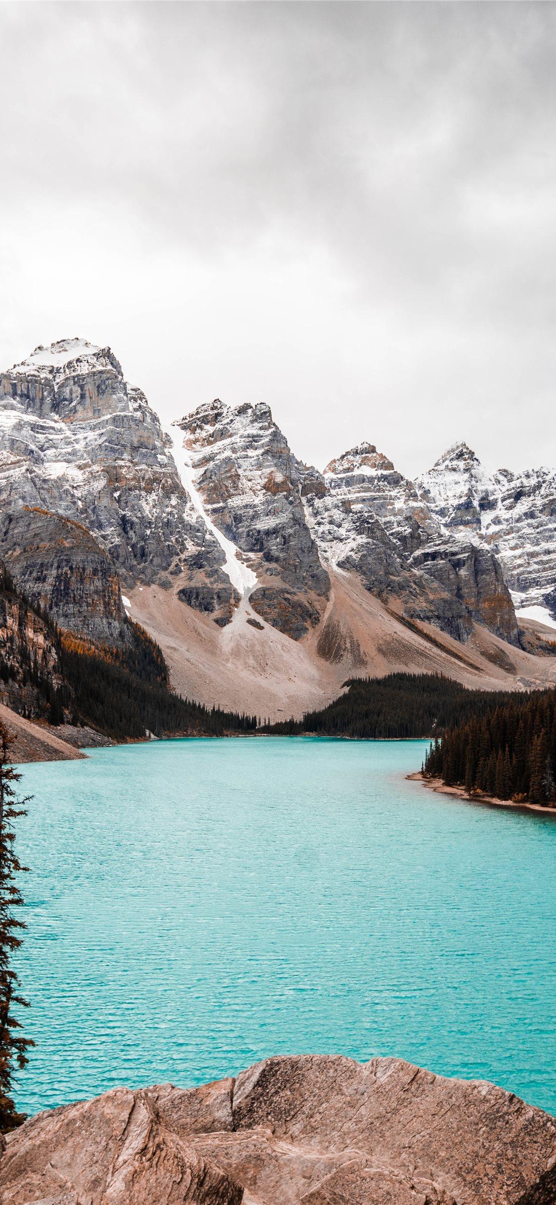 1125x2436 body of water near trees and glacier mountains dur. iPhone X Wallpaper Free Download