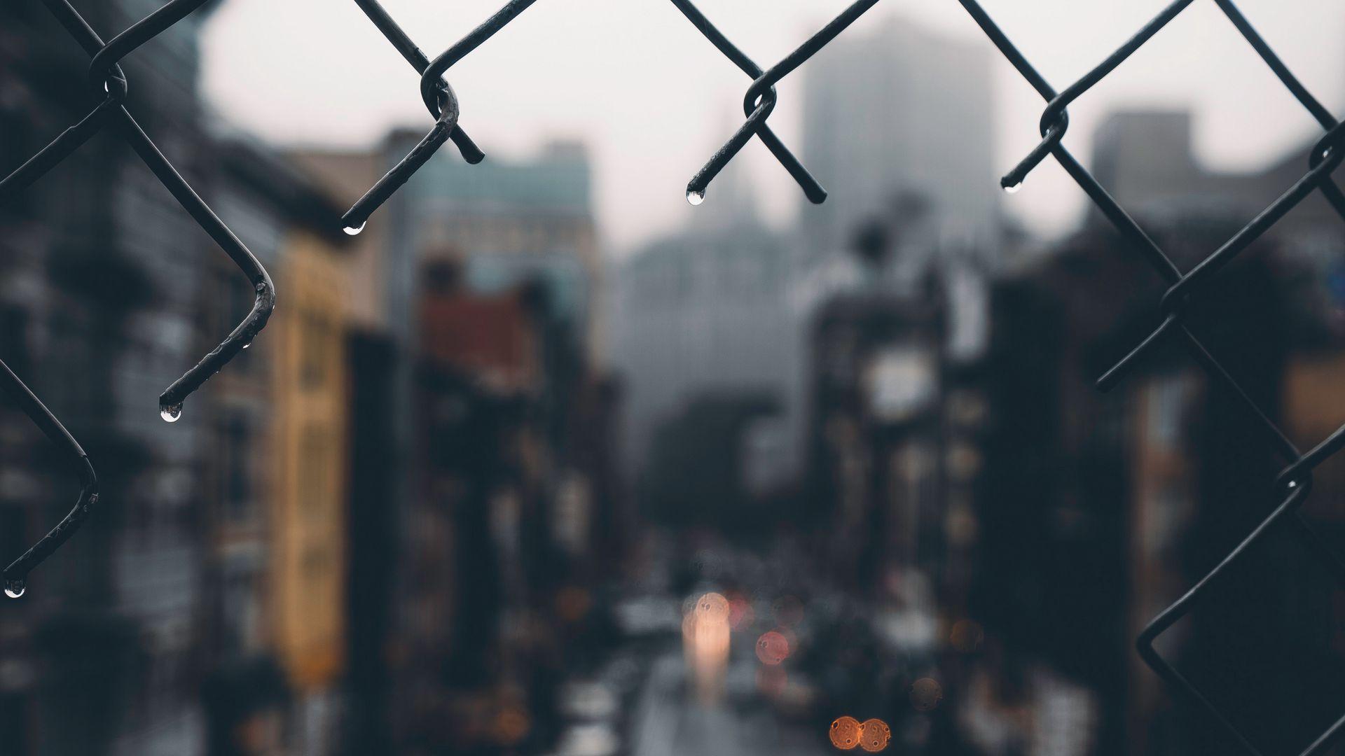 1920x1080 Download wallpaper 1920x1080 fence, grid, hole, rain, city, blur full hd, hdtv, fhd, 1080p HD background