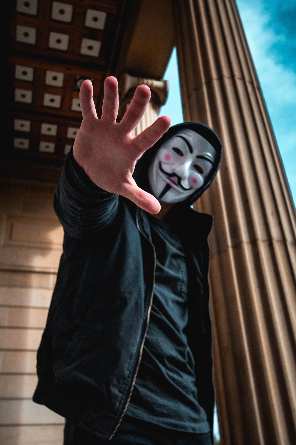 1000x1500 man wearing Guy Fawkes Mask standing inside building photo