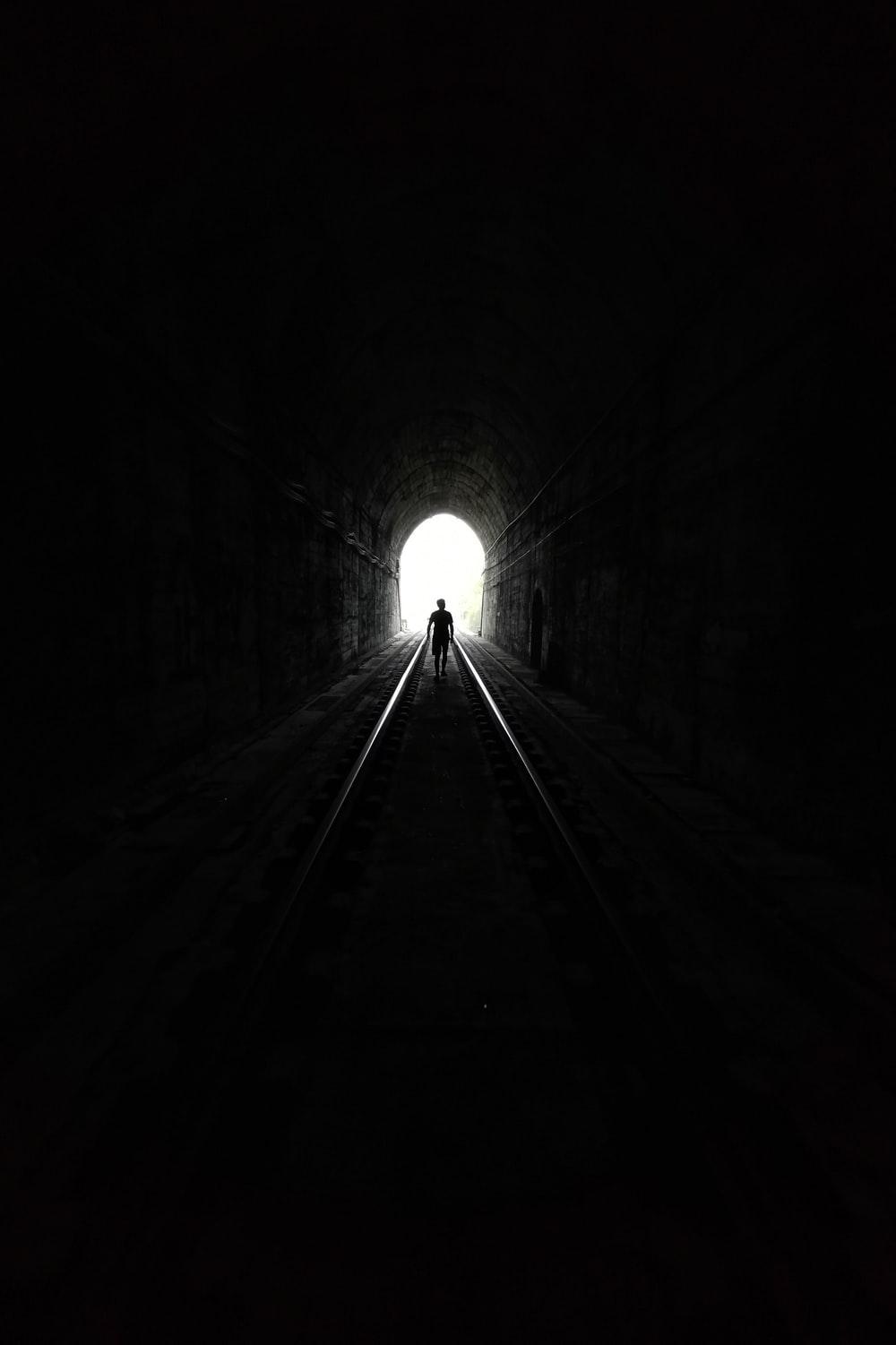 1000x1501 grayscale photo of tunnel with light photo