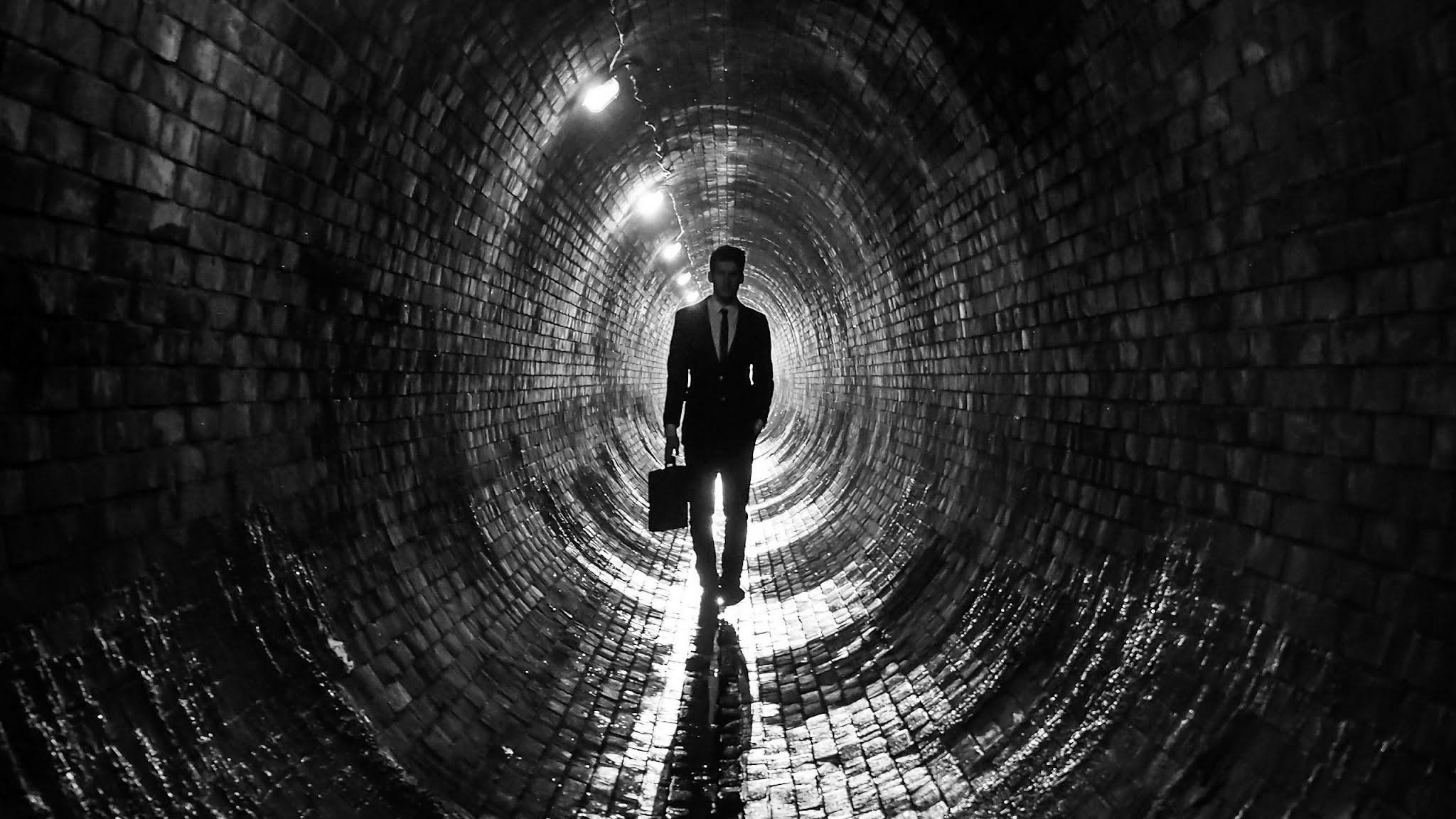 2048x1152 Man In Black Suit Walking In Tunnel Wallpaper