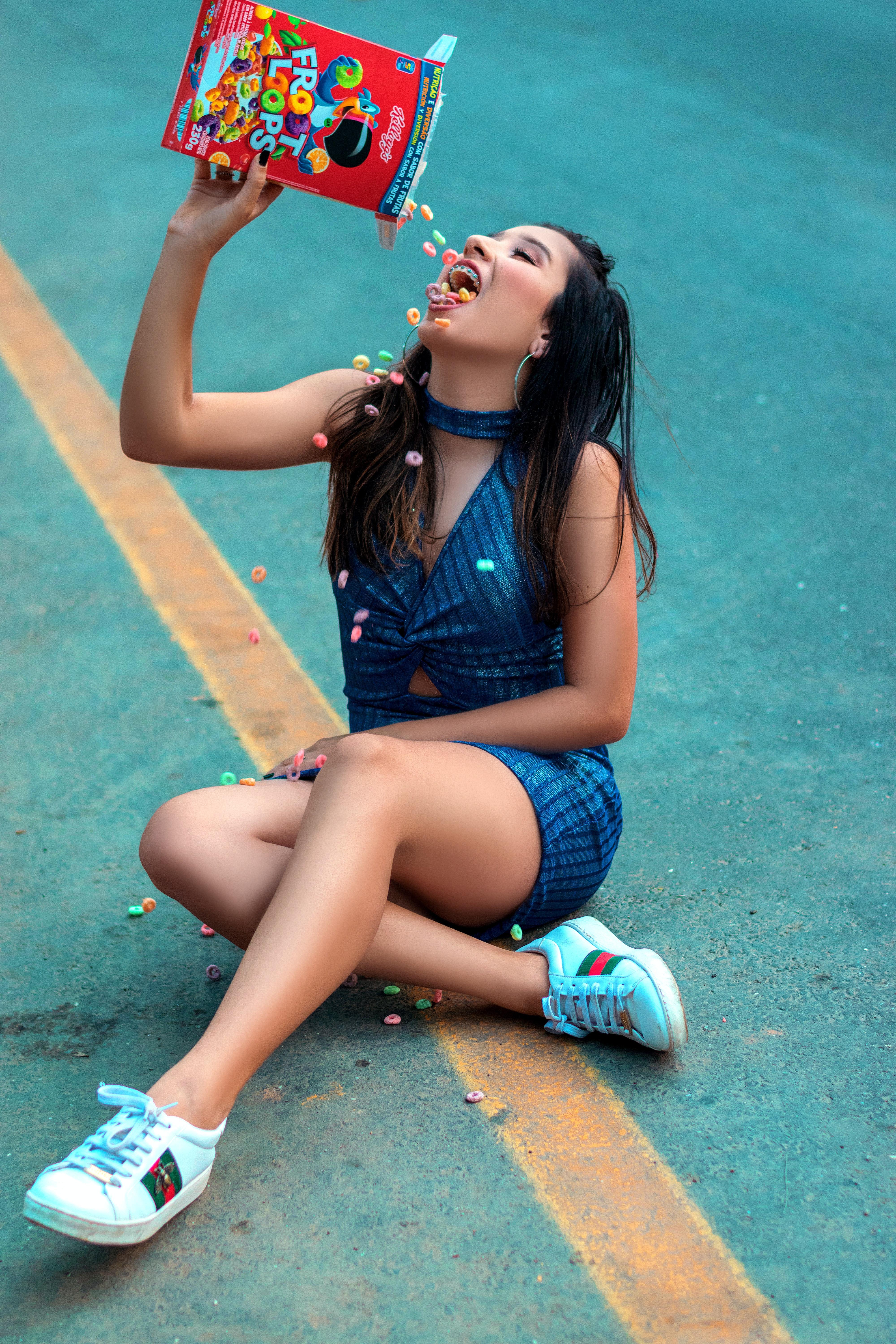 4000x6000 Woman Sitting on the Road Eating Froot Loops · Free