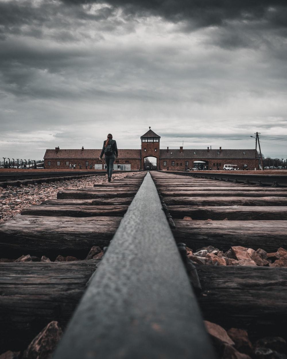 1000x1250 person walking on train tracks during daytime photo
