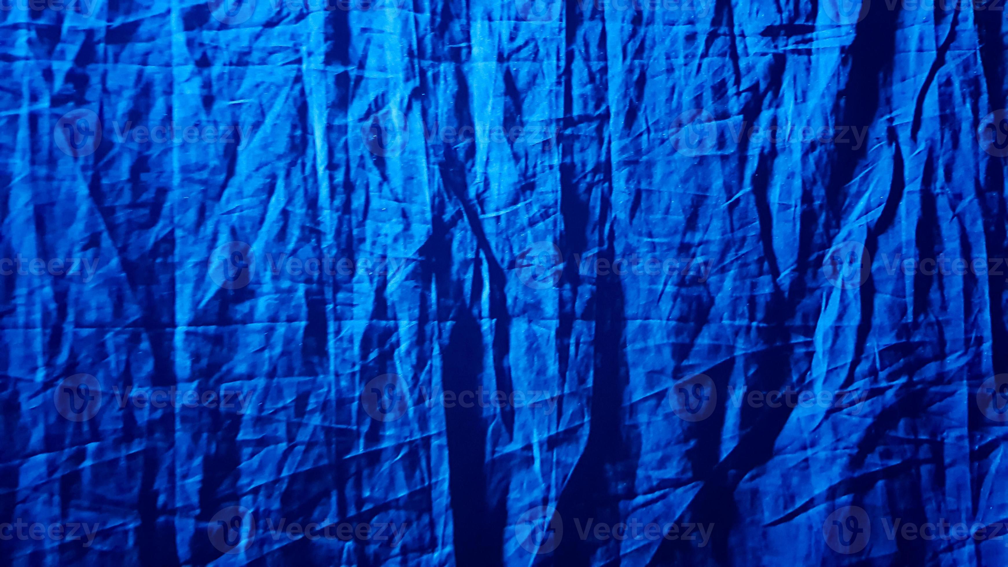 3484x1960 Fabric blue background for your design. A blue ray of light diagonally illuminates the dark black wrinkled, dense fabric. Background, pattern, texture, wallpaper. Add a touch of luxury to any design 4539019