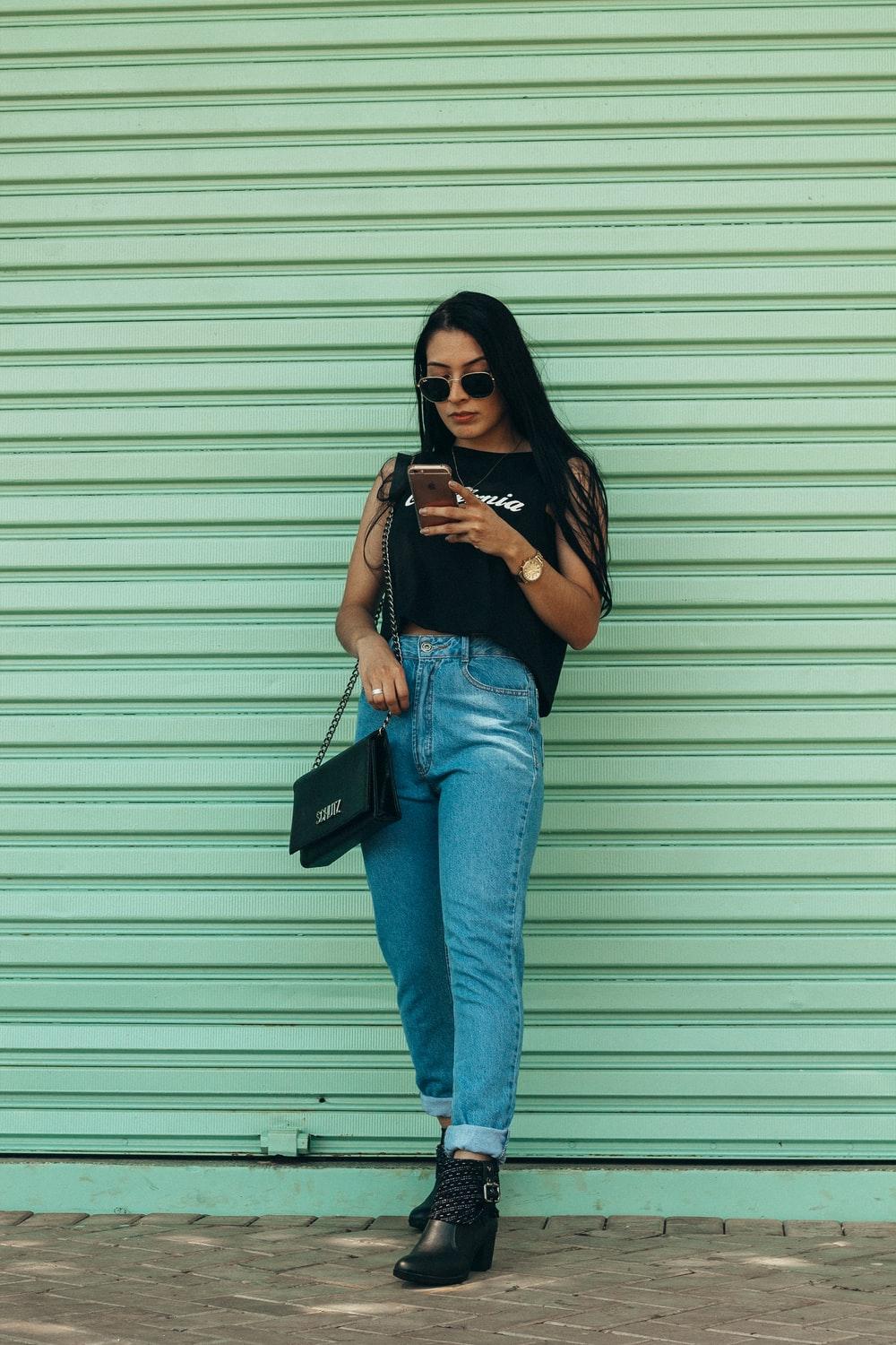 1000x1500 woman in black sleeveless top holding smartphone outdoors photo