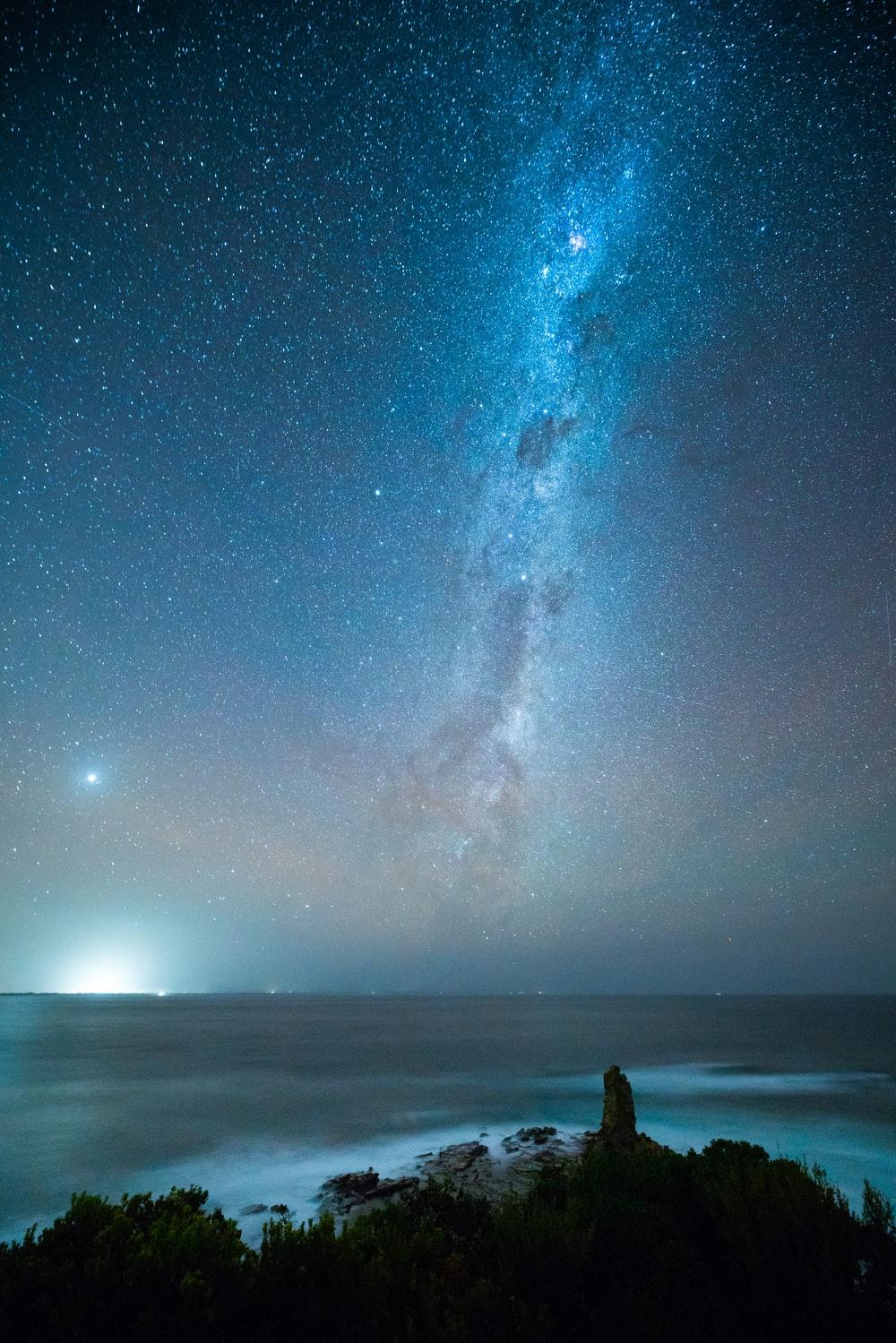 1000x1499 person standing on beach under starry night photo