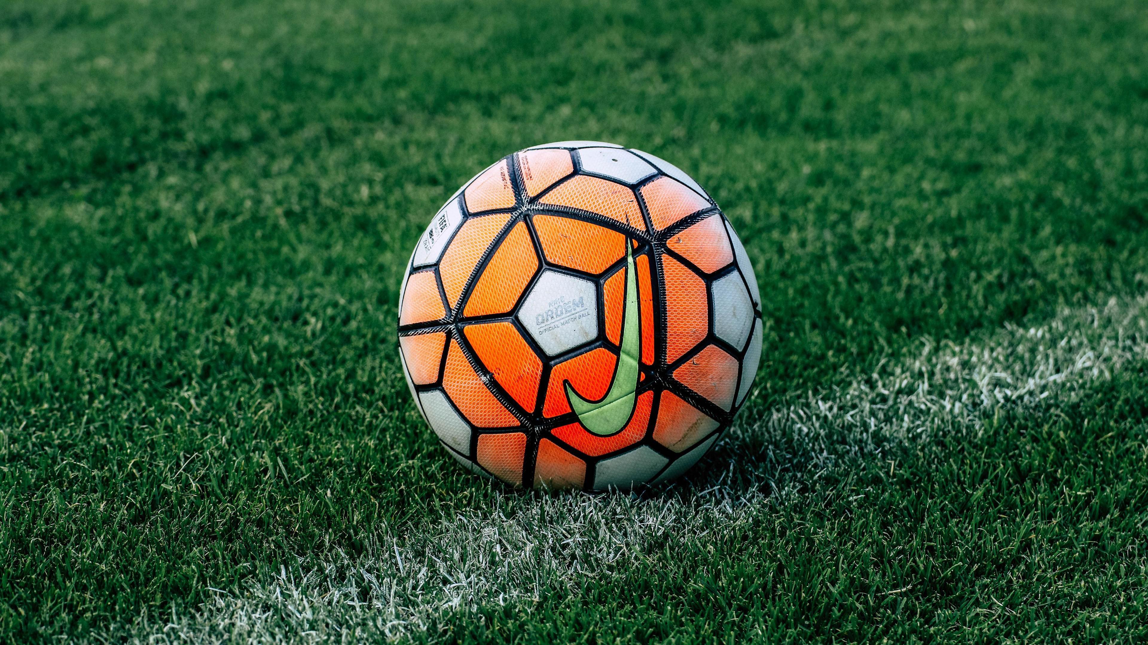 3840x2160 White Orange Black Football On Green Grass 4K HD Football Wallpaper