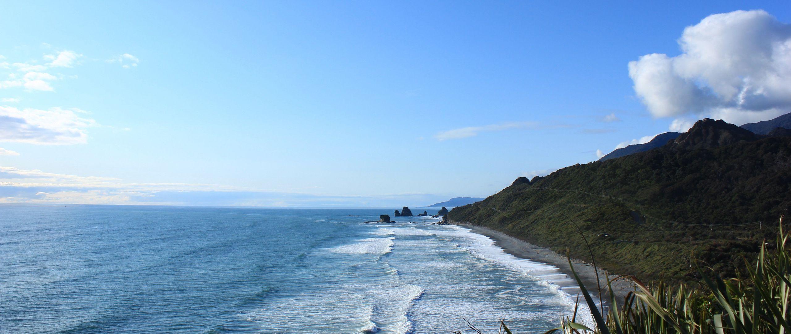 2560x1080 Download wallpaper 2560x1080 new zealand, sea, mountain, beach dual wide 1080p HD background