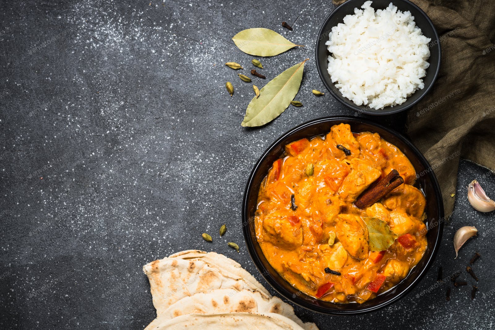1600x1067 Chicken tikka masala with rice on black top view photo by Nadianb on Envato Elements