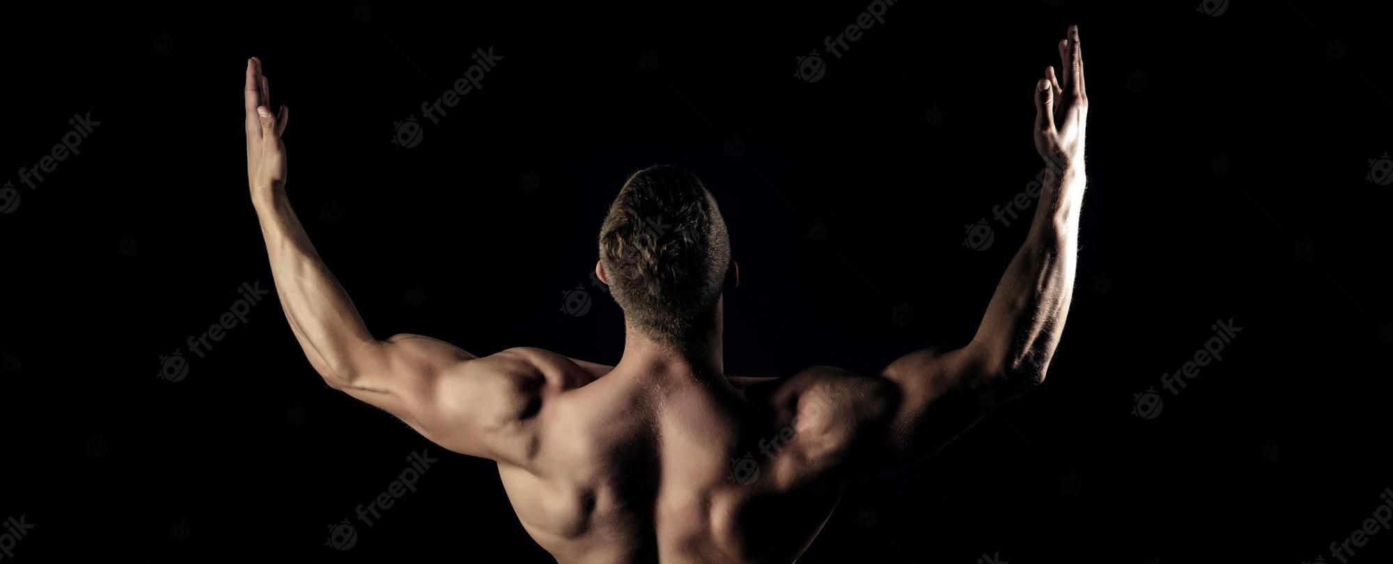 2000x810 Premium Photo. Bodybuilder man show biceps triceps with raised hands back banner templates with muscular man muscul
