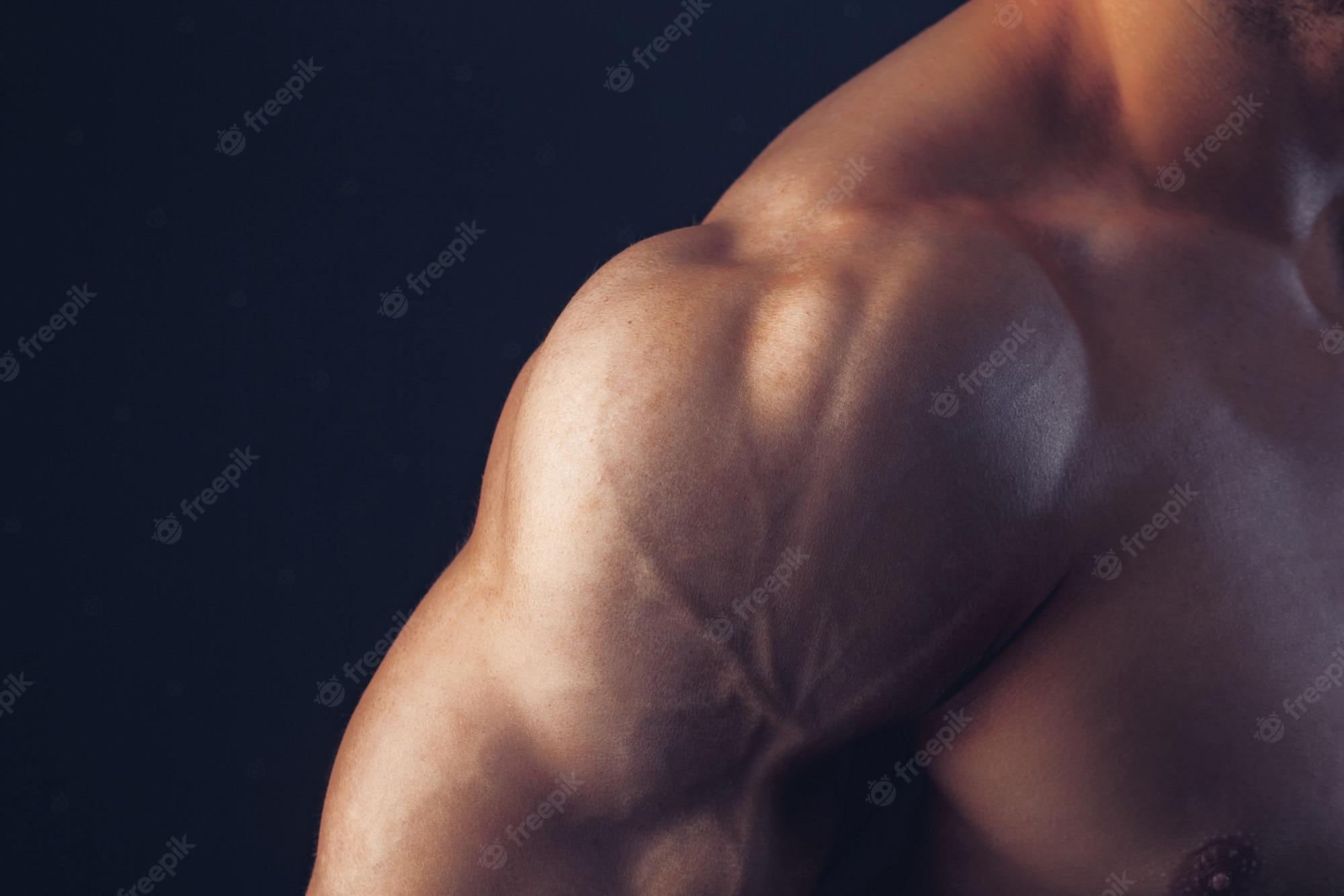 2000x1333 Premium Photo. Fitness man background shoulder biceps pectoral muscles triceps bodybuilder on a dark background demonstrates the physical form for classes in