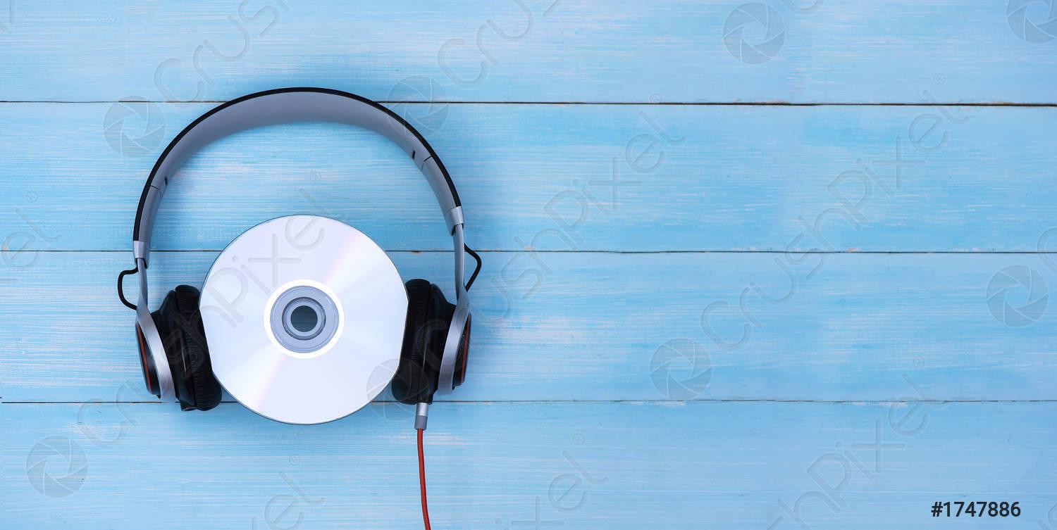 1500x753 Wired headphones with compact disk on blue pastel background Retro
