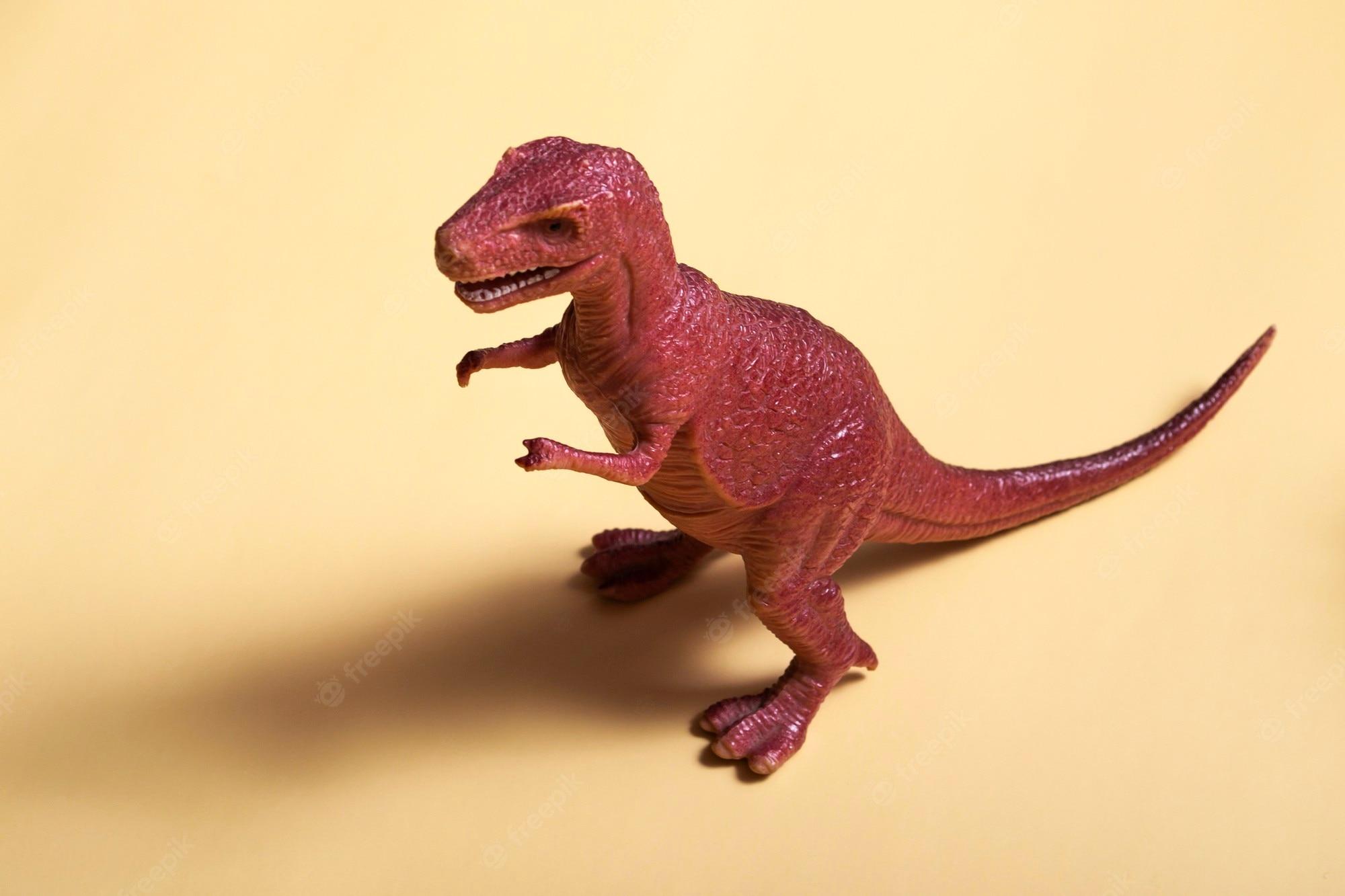 2000x1333 Premium Photo. Toy plastic dinosaur on a colored background. concept texture, design, wallpaper, decor, textiles