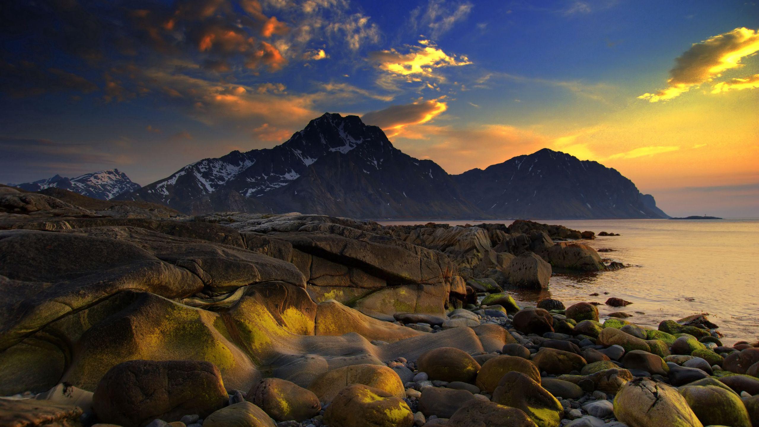 2560x1440 Download wallpaper 2560x1440 coast, stones, smooth, wet, sea, mountains, evening, sky HD background