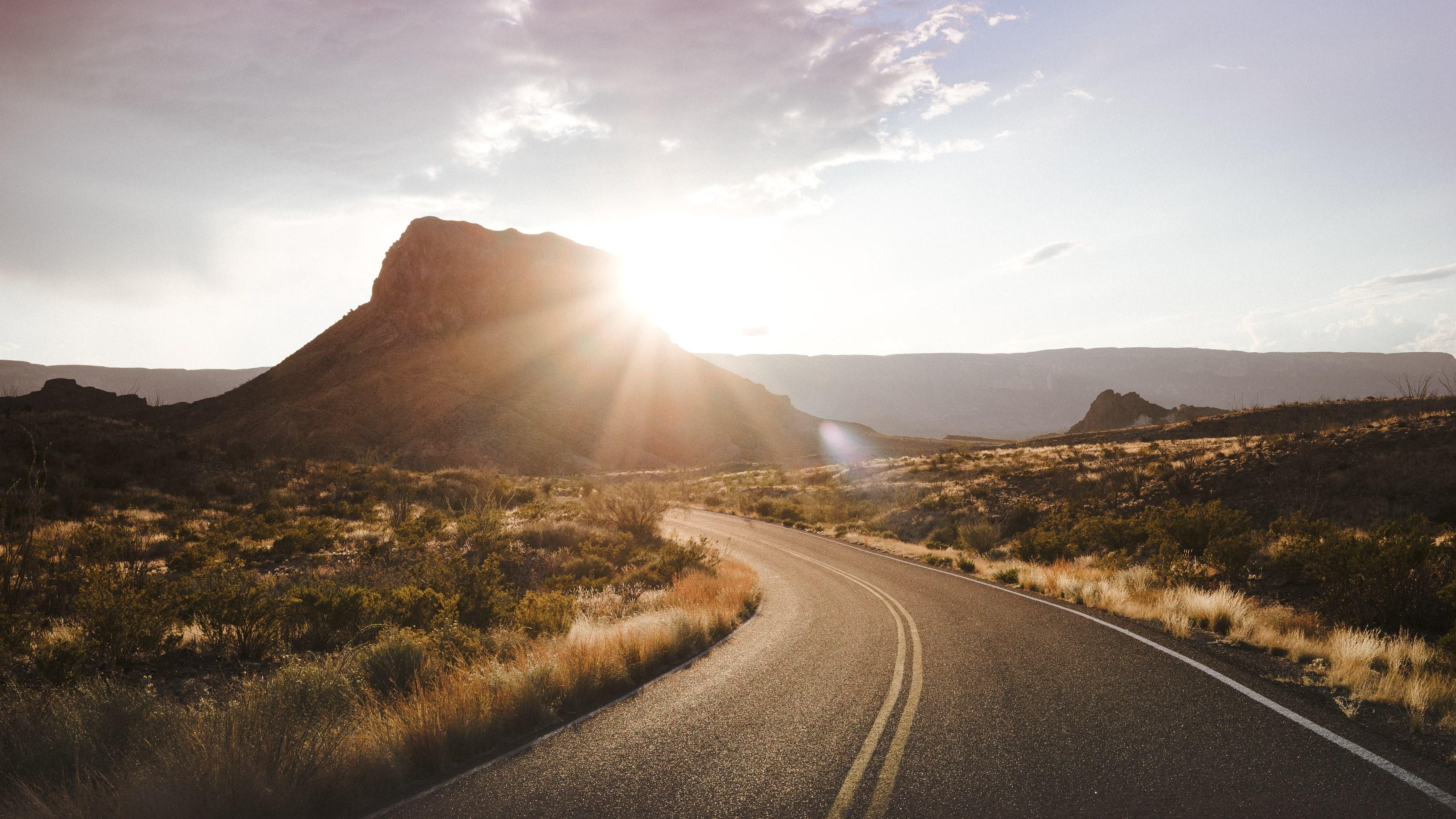 3600x2025 Wallpaper / a paved road in big bend national park with the sunlight coming from behind a hill, sunset southwest 4k wallpaper free download