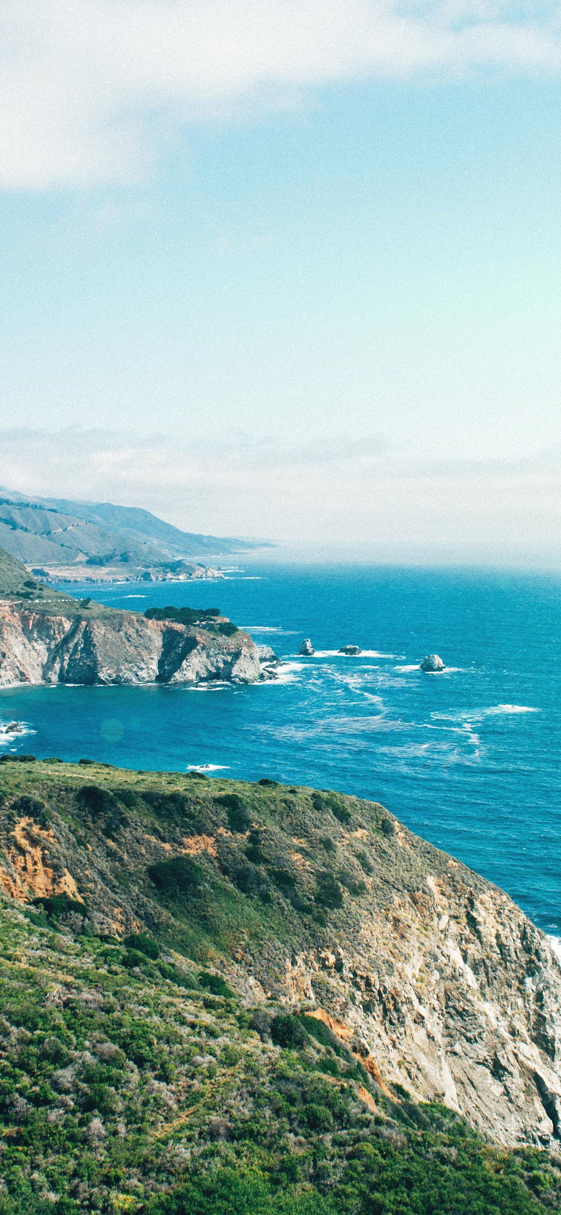 1125x2436 sea mountain green beach nature flare