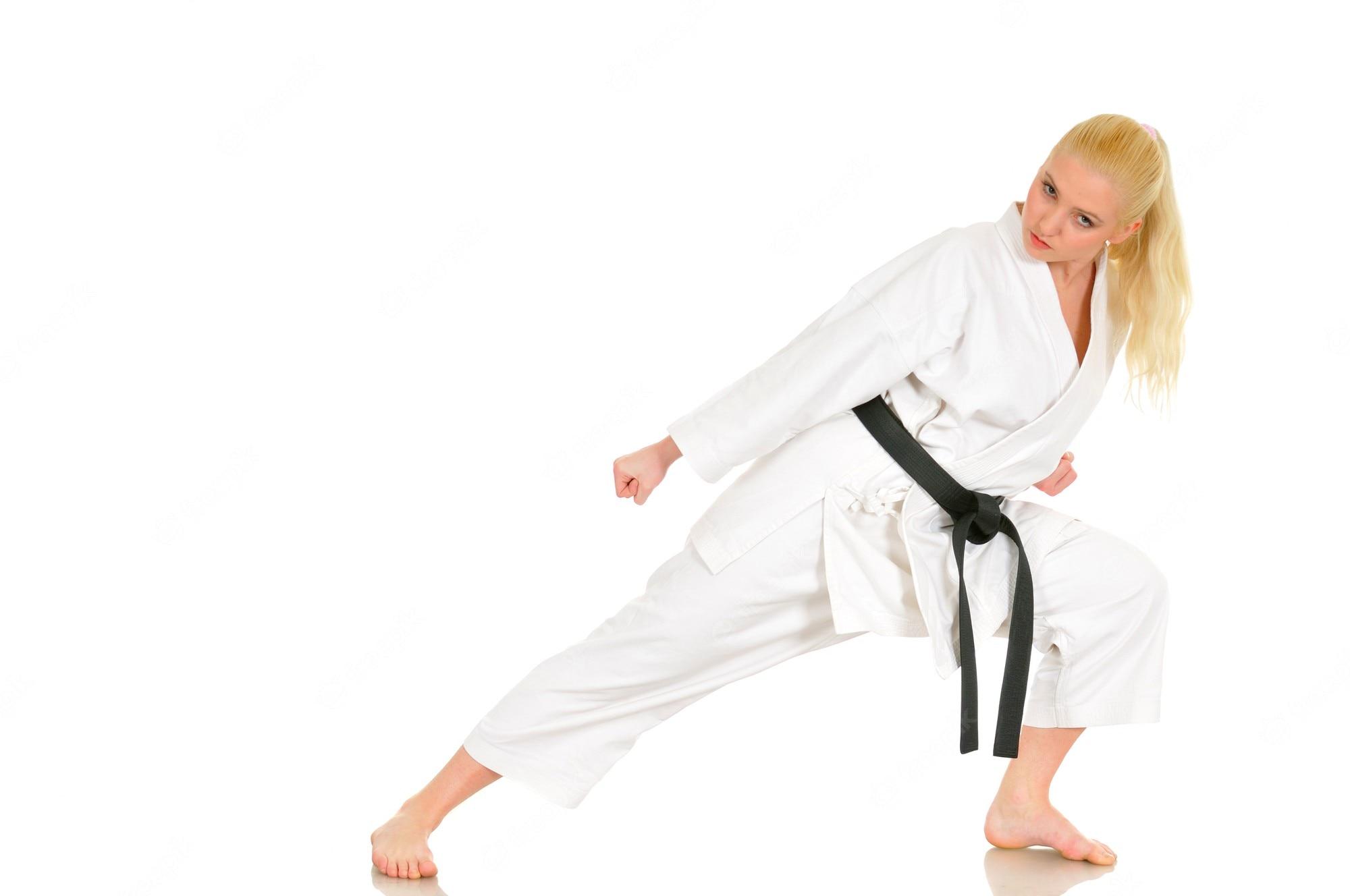 2000x1328 Premium Photo. Beautiful young girl blonde karate sportswoman in a kimono makes a position to start workout
