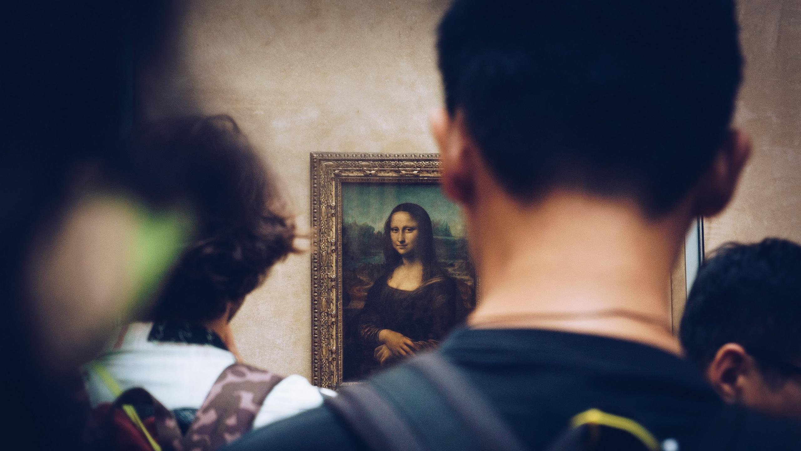 2560x1440 Wallpaper / picture from behind of people viewing the mona lisa in louvre art gallery in paris, mona lisa being admired 4k wallpaper free download