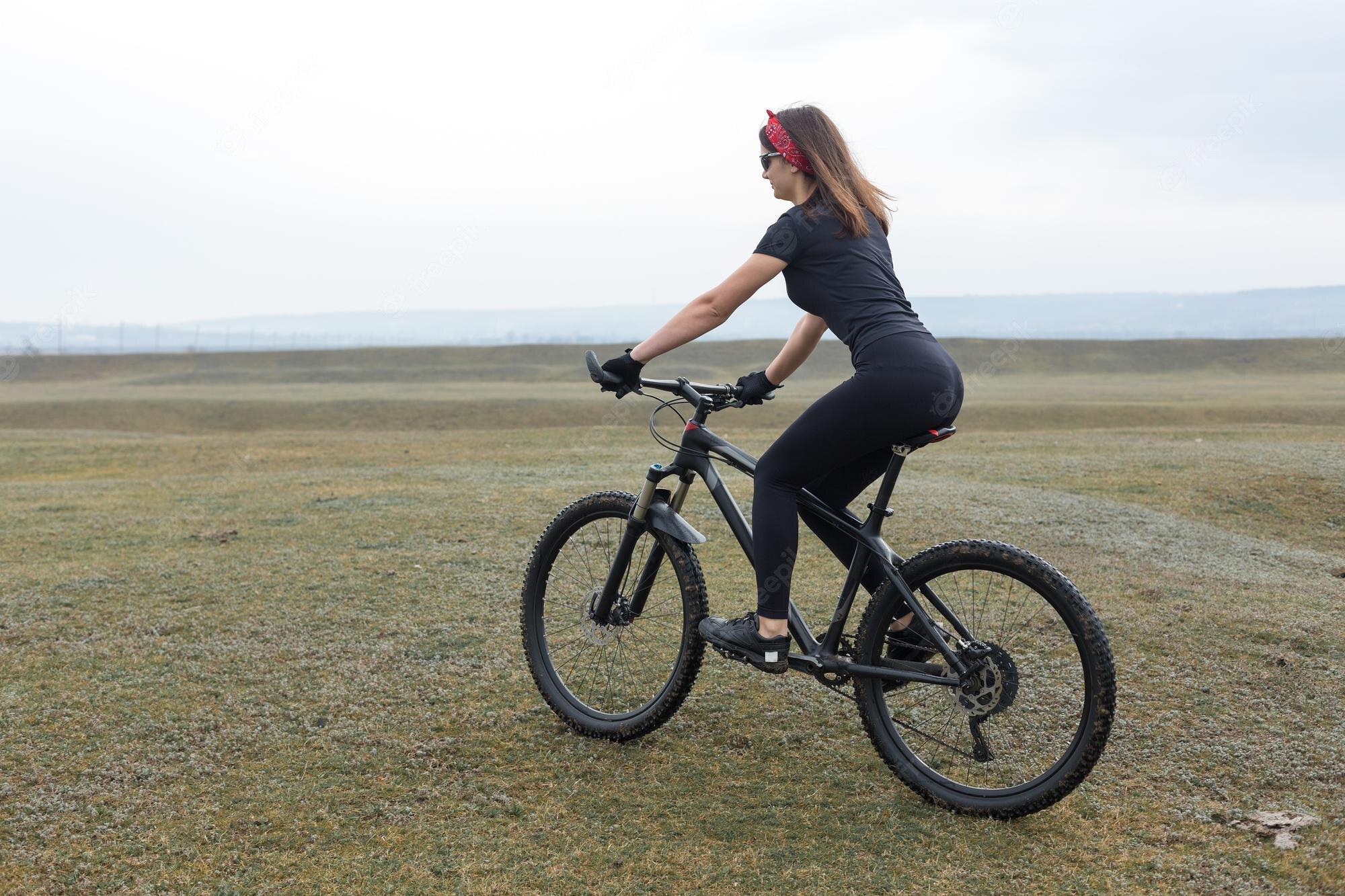 2000x1333 Premium Photo. Girl on a mountain bike on offroad beautiful portrait of a cyclist in rainy weather fitness girl rides a modern carbon fiber mountain bike in sportswear closeup portrait of