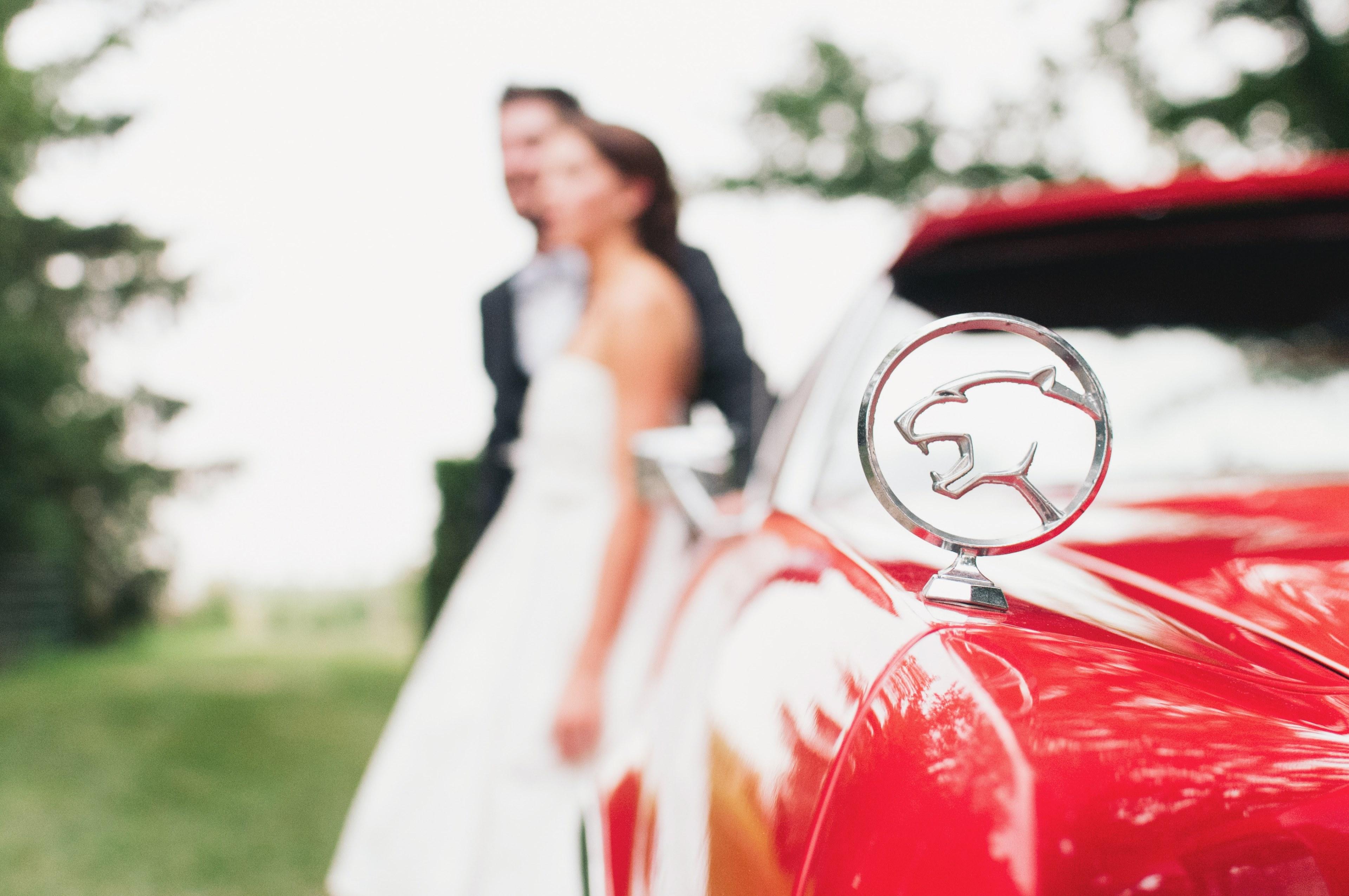 3840x2551 Wallpaper / vintage red jaguar car with married couple in background out of focus, wedding with red car 4k wallpaper free download