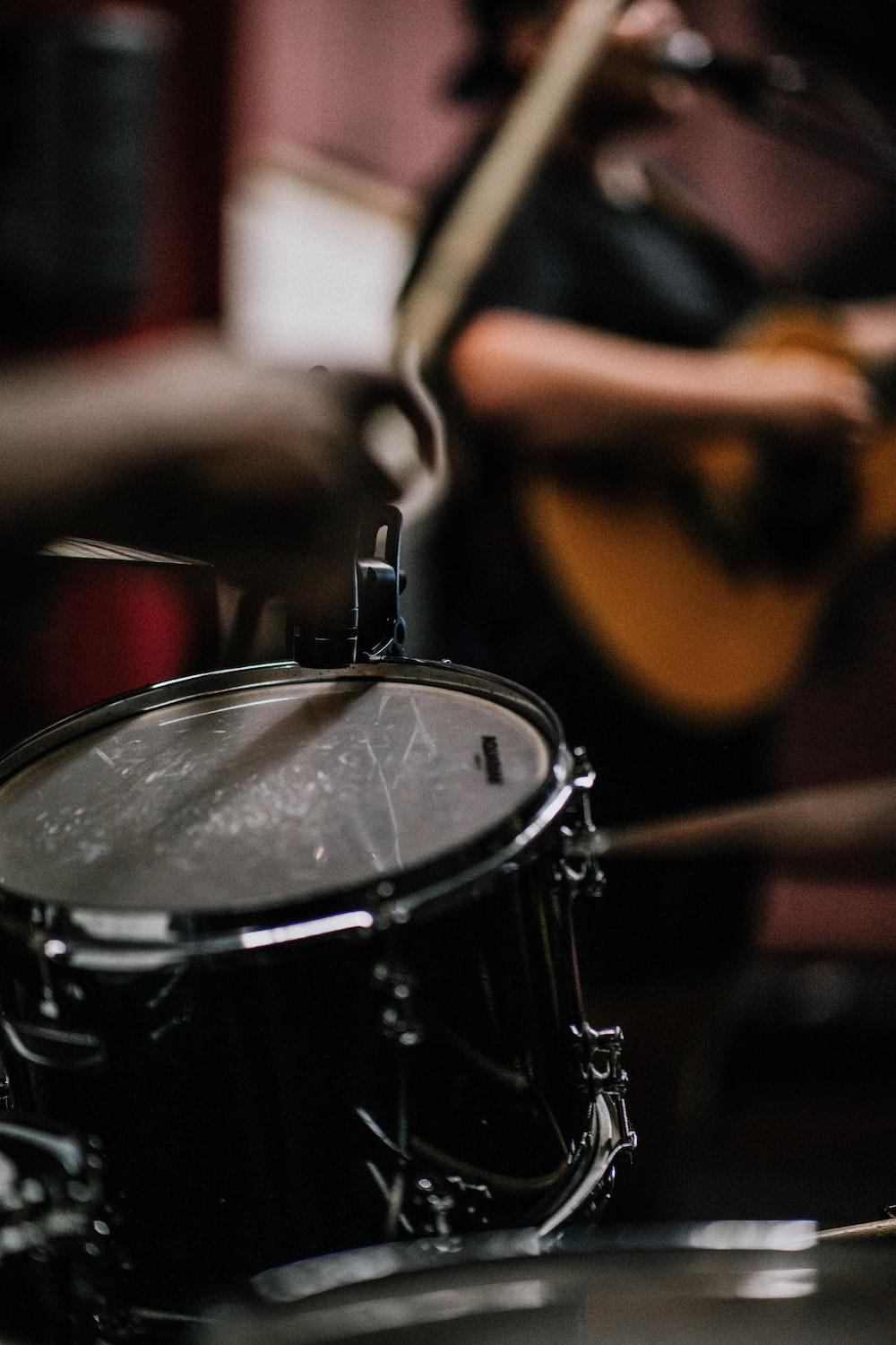 1000x1500 person playing guitar near drums photo
