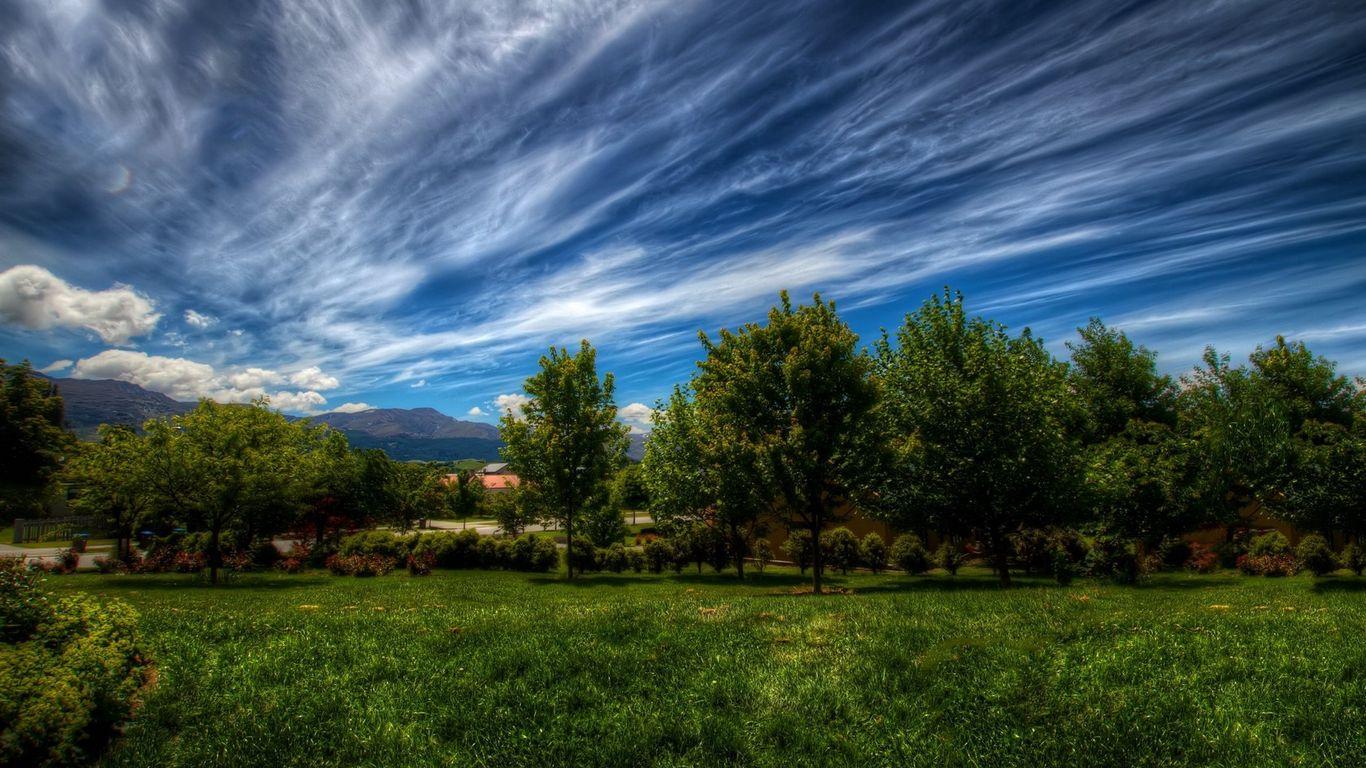 1366x768 Download wallpaper 1366x768 clouds, sky, summer, dark blue, green, white, trees, garden tablet, laptop HD background
