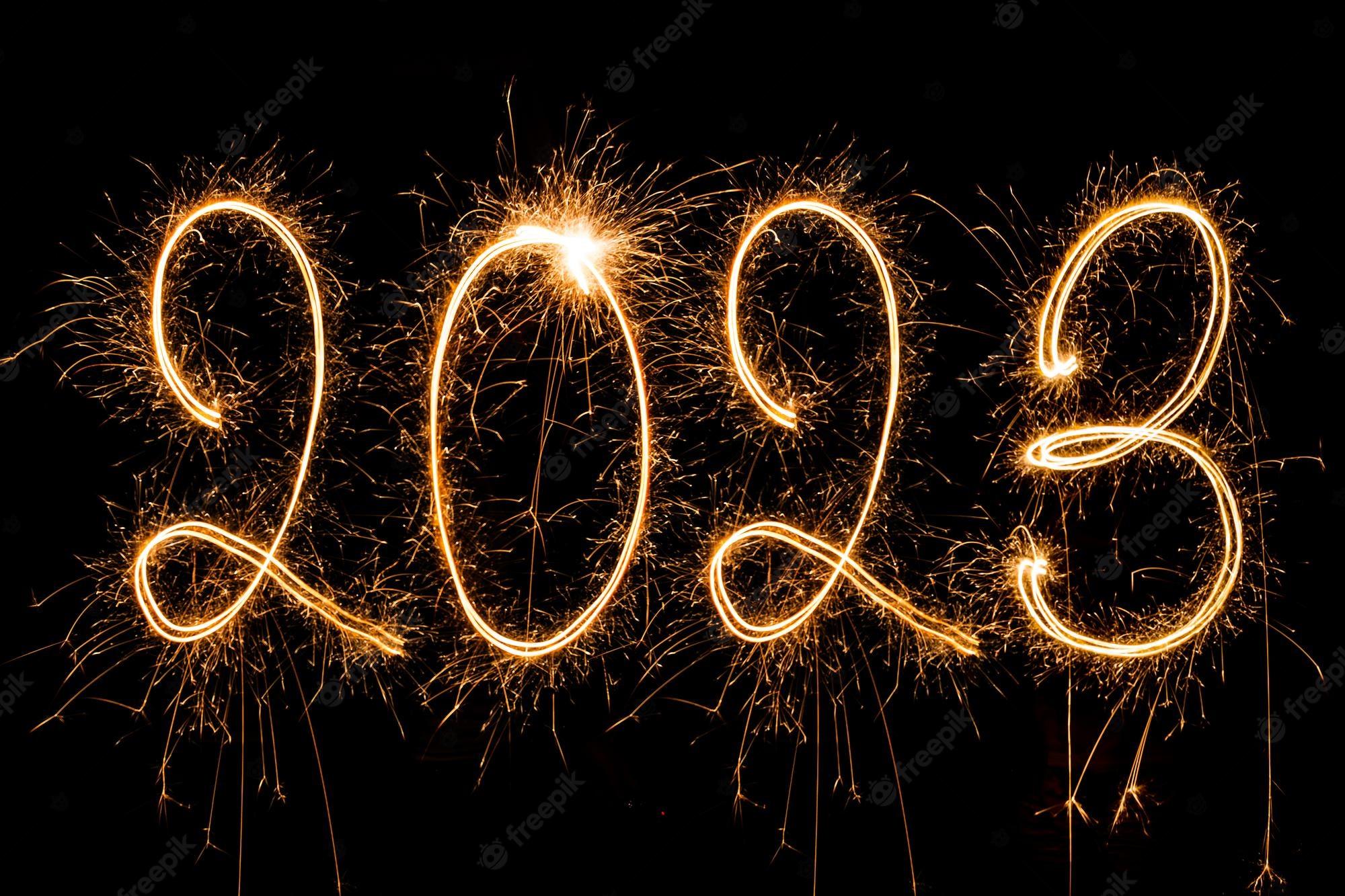 2000x1333 Free Photo. Happy new year 2023. sparkling burning text happy new year 2023 isolated on black background. beauti