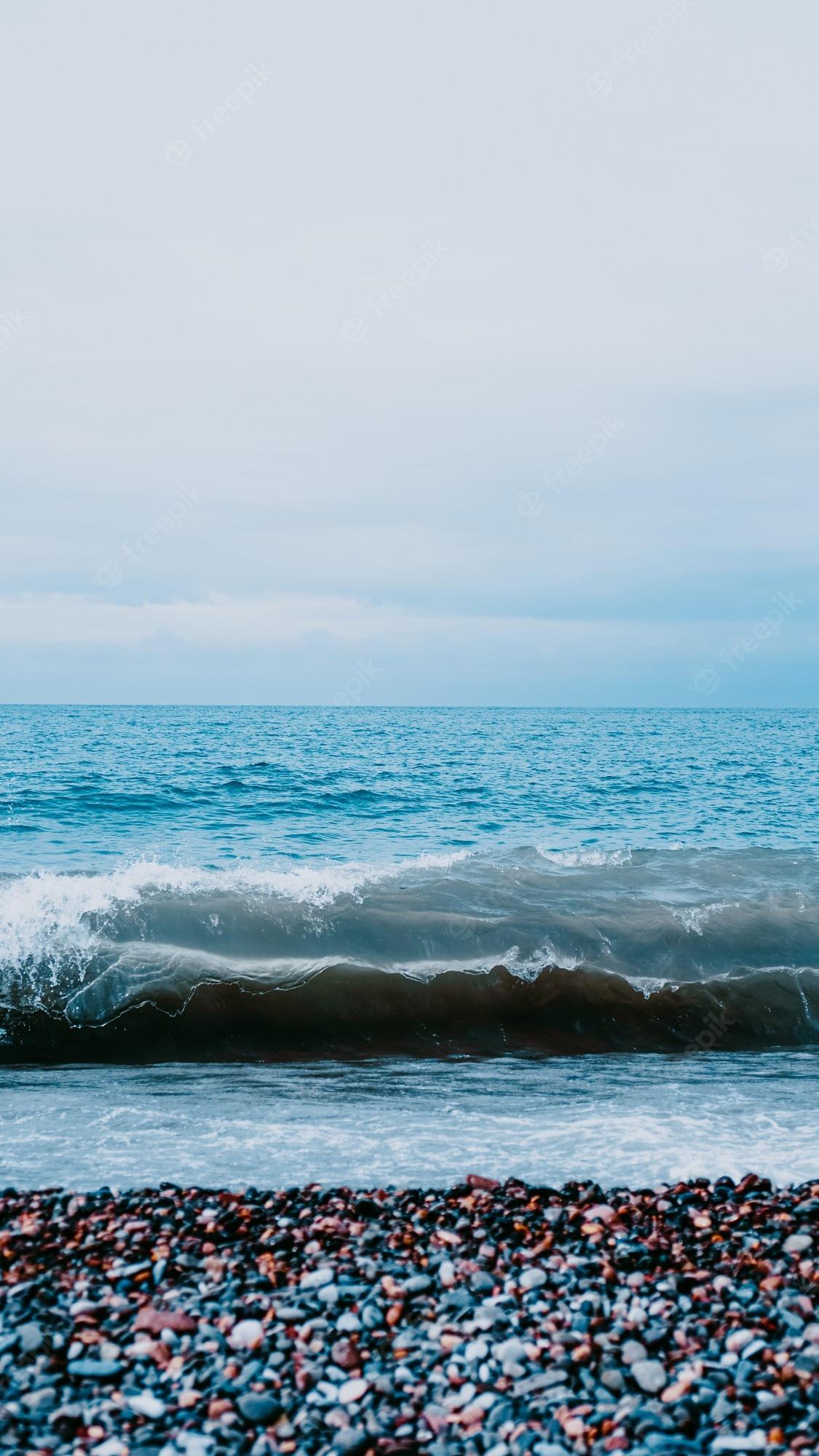 1125x2000 Premium Photo. Vertical view from above of sea. perfect for vertical wallpaper. meditation on the sea stones. selective focus