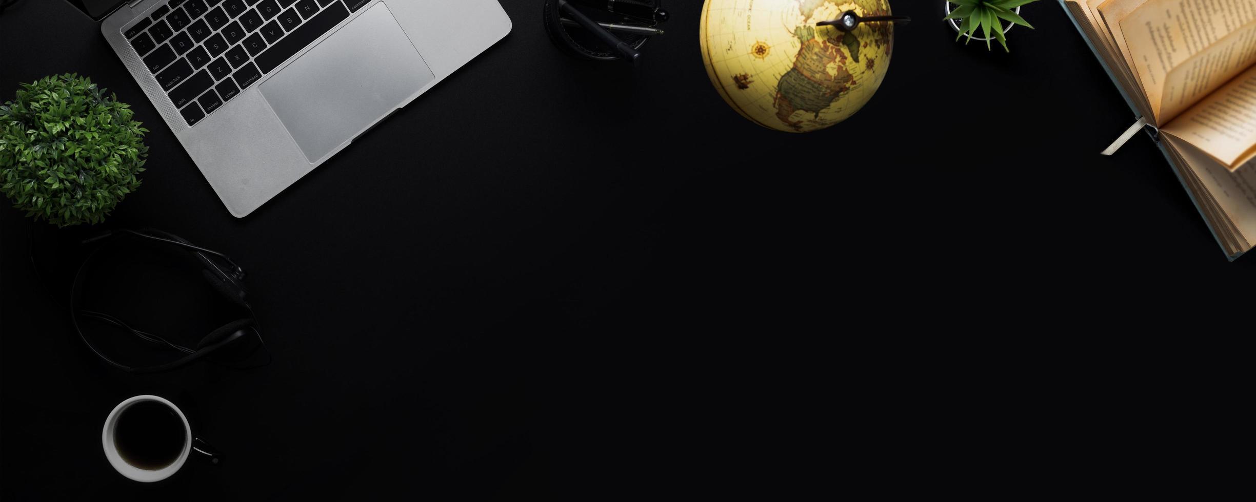 2449x980 top view dark and black background with laptop and book and learning geography and history with global earth map ball, education concept