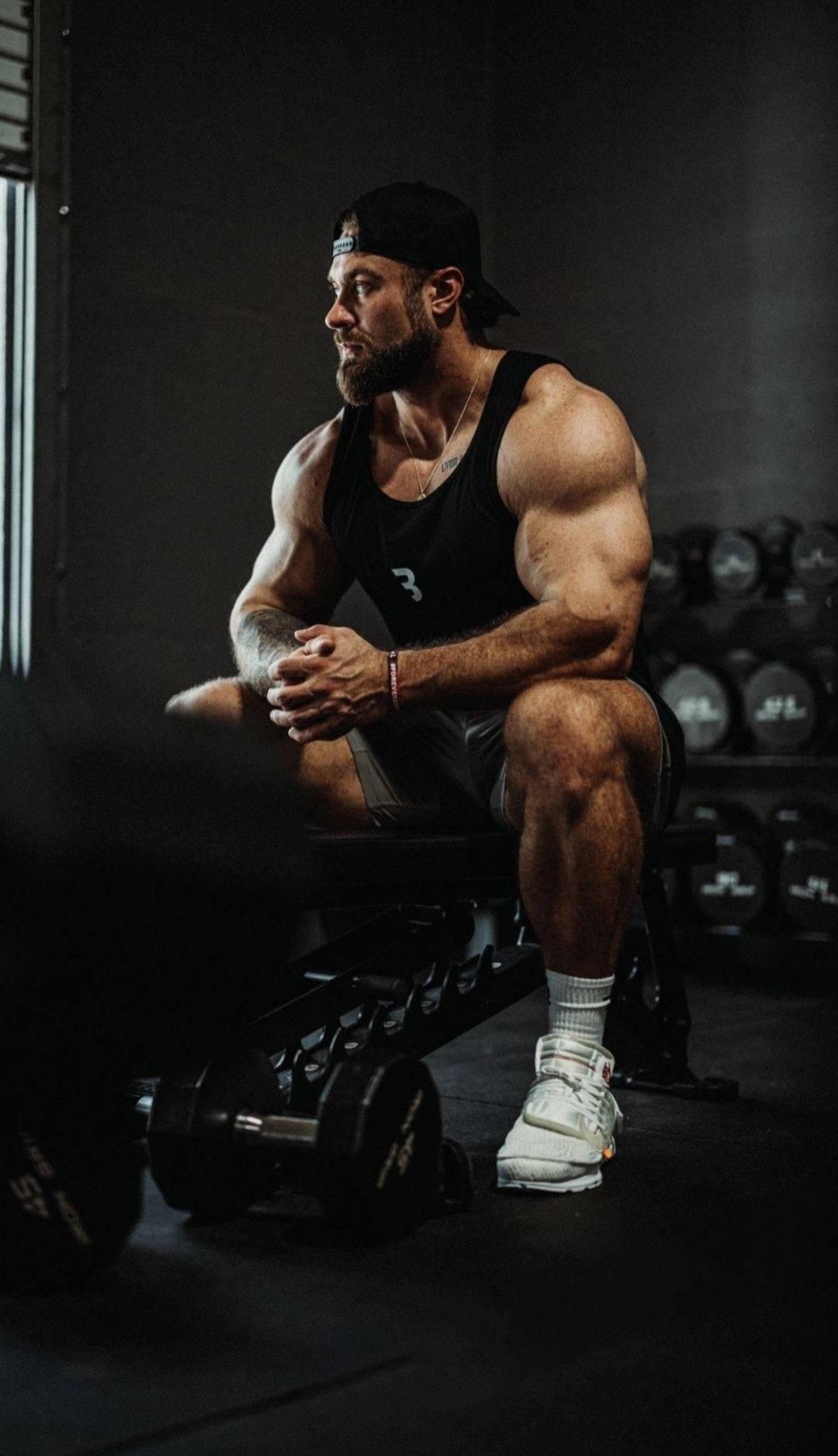 1080x1877 Download Chris Bumstead Sitting On Weight Bench Wallpaper
