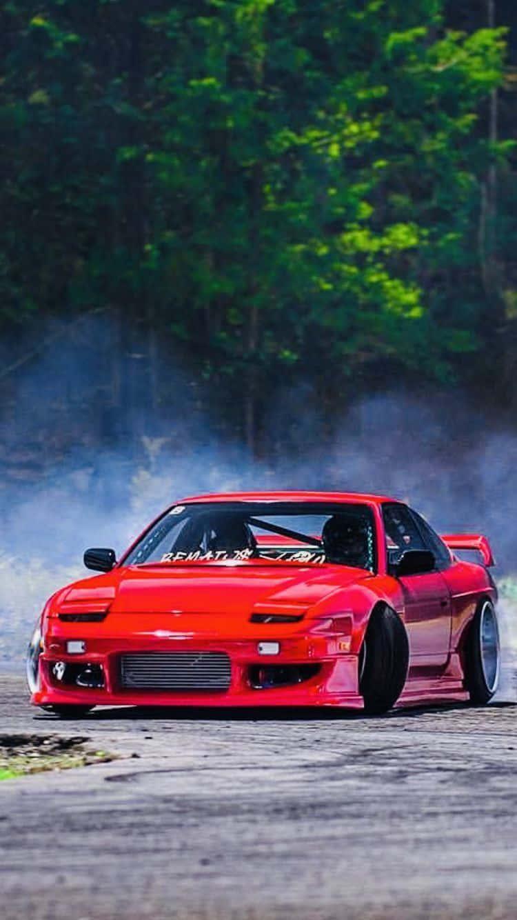 750x1334 Download A Red Drift Car Driving Down A Track Wallpaper