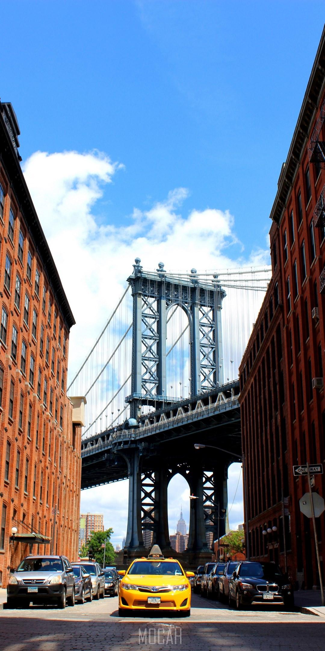 1080x2160 a taxi driving down a new york city street with the manhattan bridge in the background, bright yellow cab, LG Q7 wallpaper HD free download, 1080x2160 Gallery HD Wallpaper