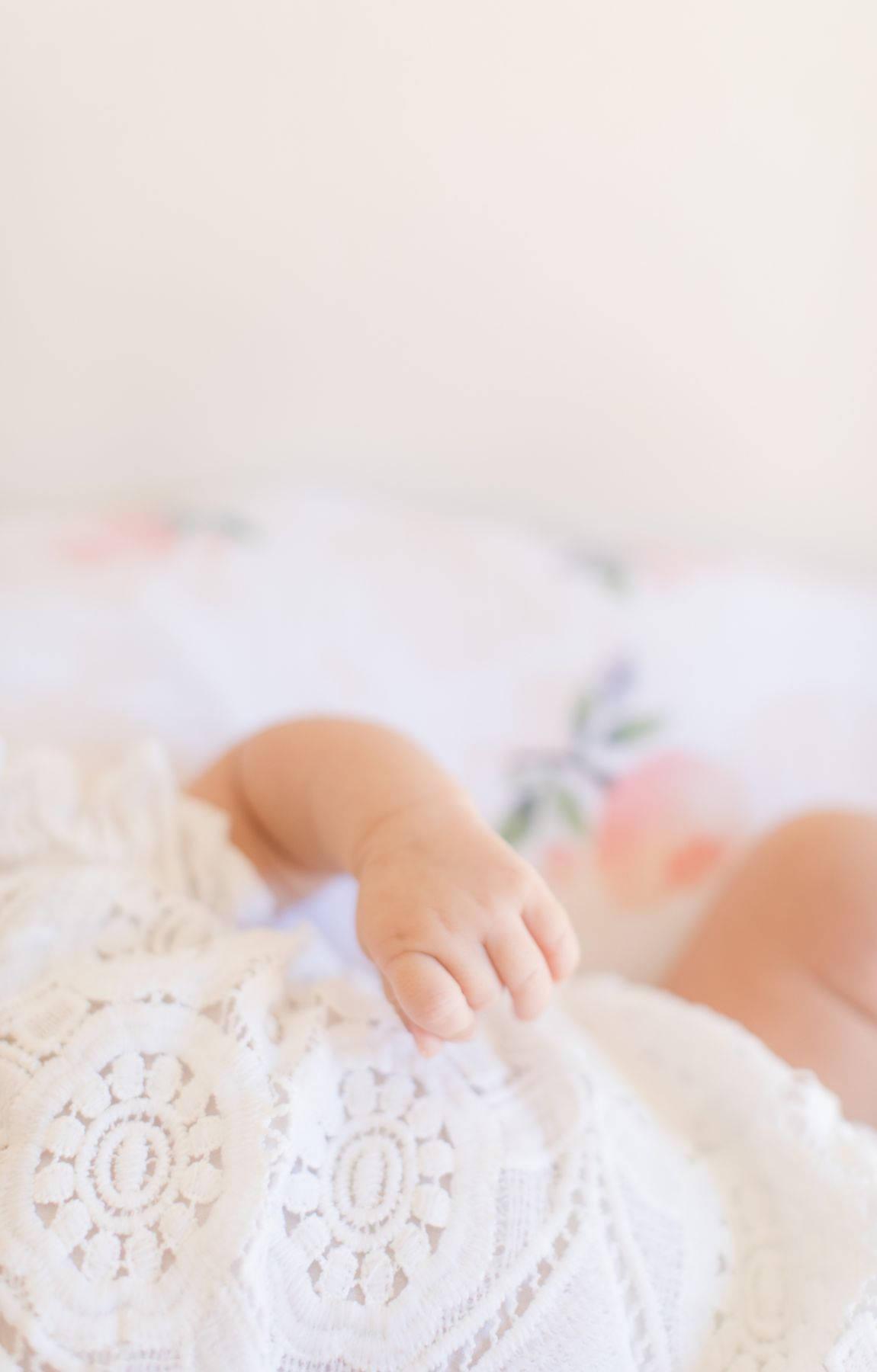 1150x1800 Download Baby Hand In White Baby Clothes Wallpaper