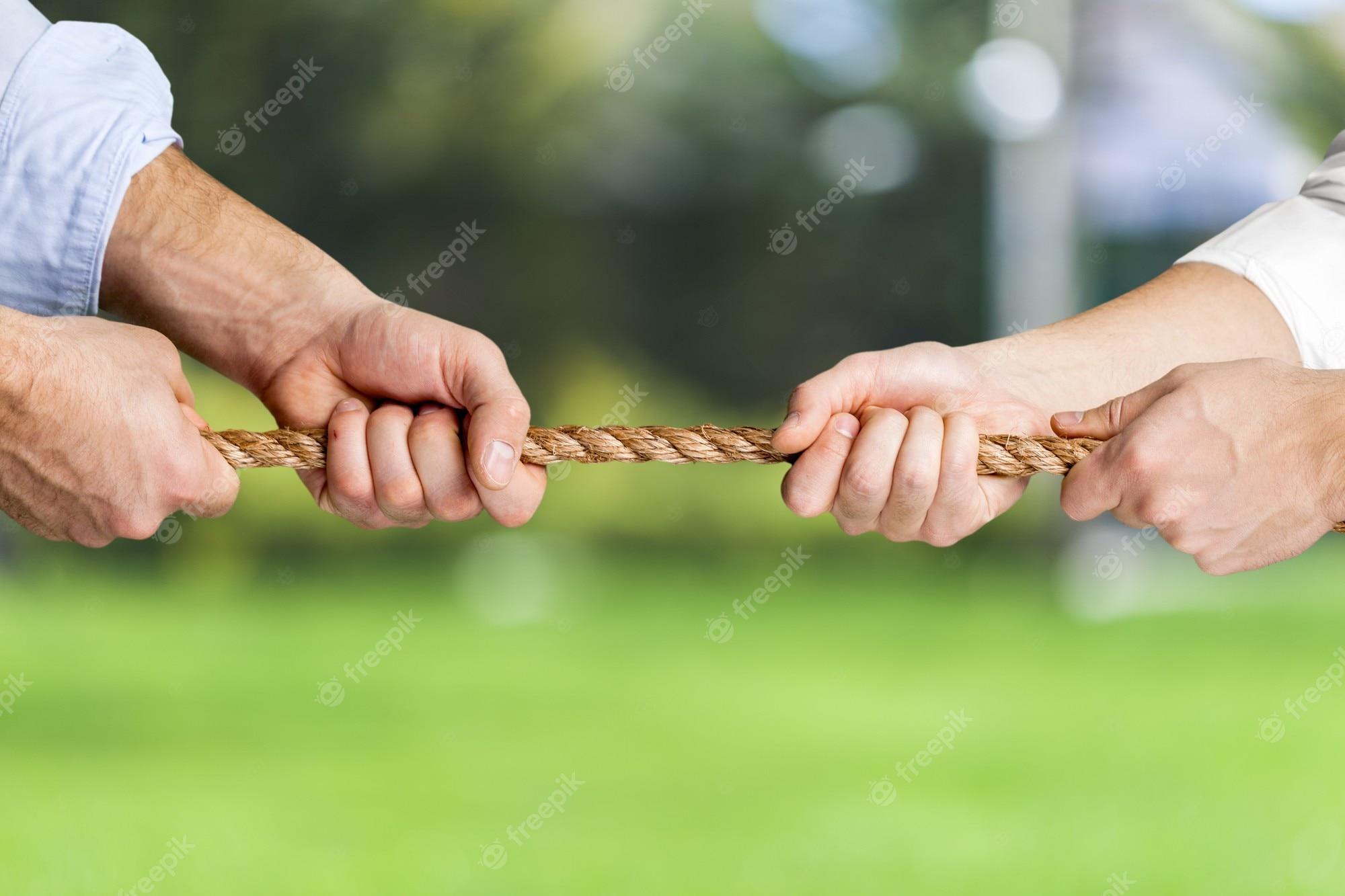 2000x1333 Premium Photo. Tug war, two businessmen pulling a rope in opposite directions isolated on naturebackground