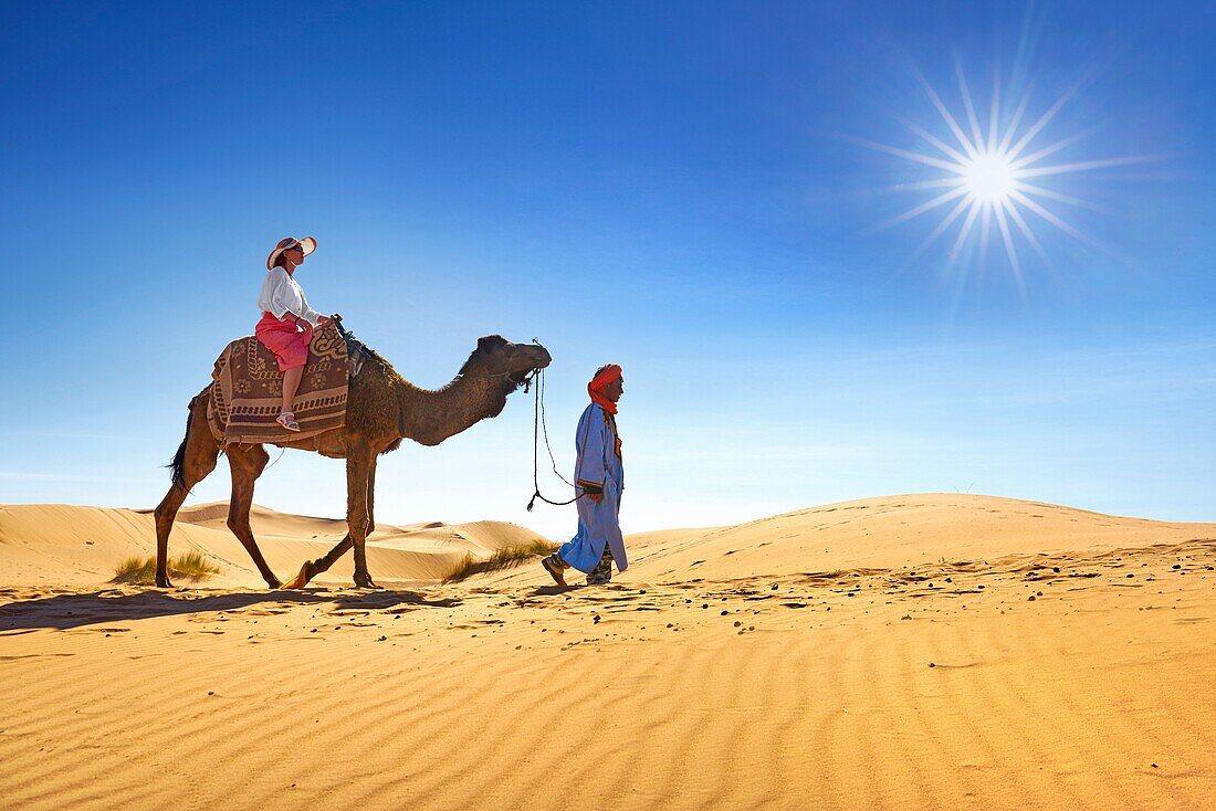 1100x734 Tourist on camel ride, Erg Chebbi desert