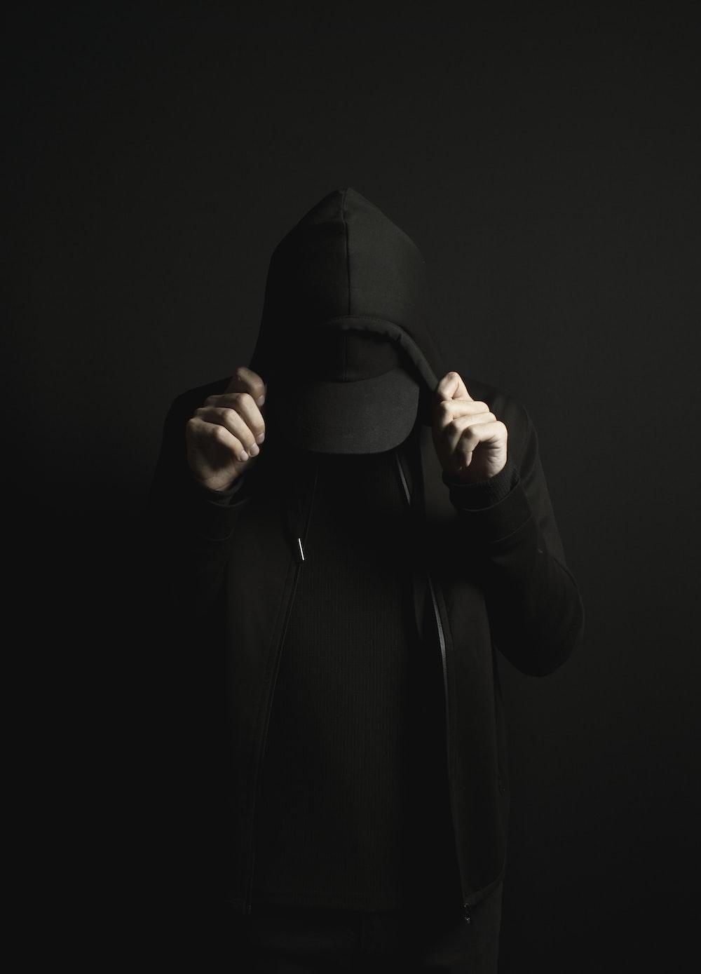 1000x1389 A person wearing a black hoodie and a black hat photo