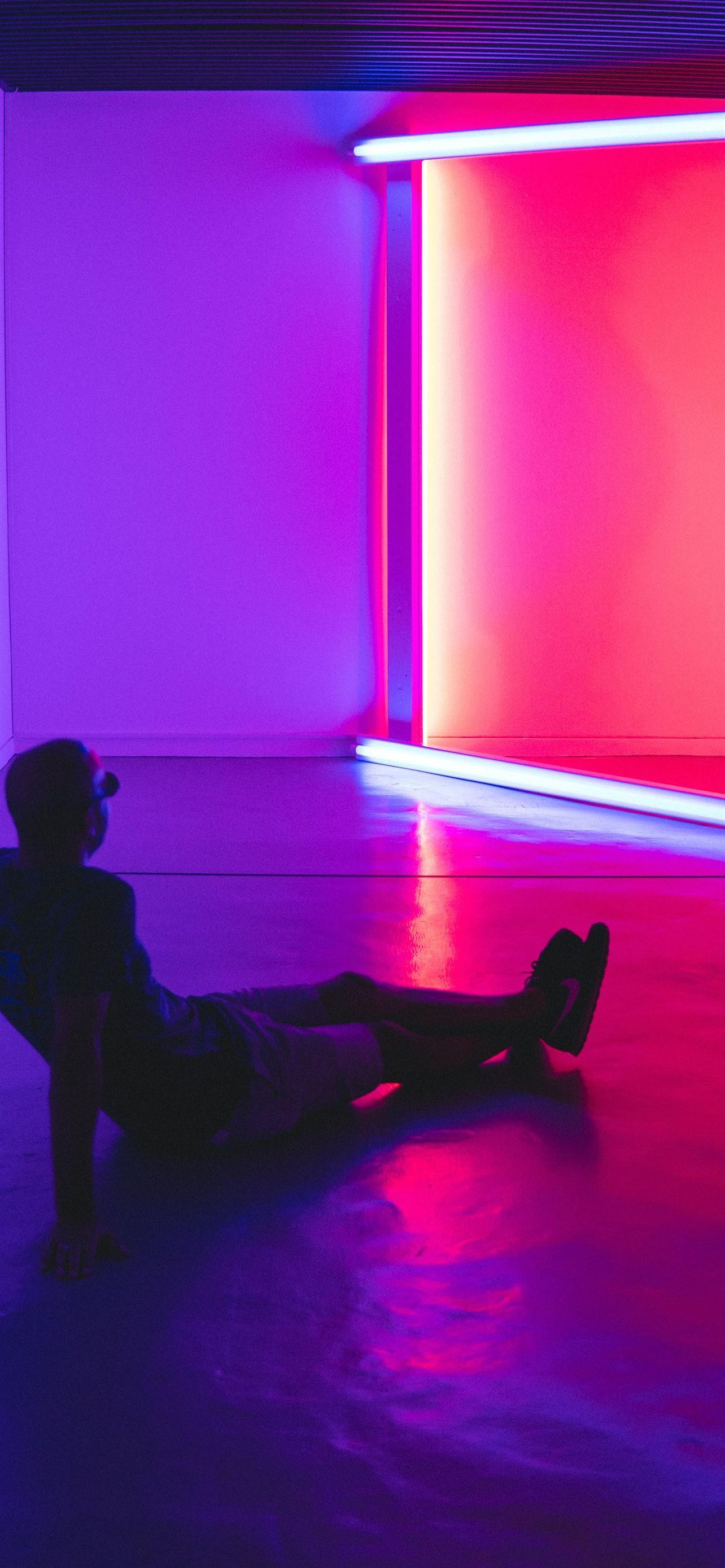 1284x2778 man sitting on floor facing a lighted room area iPhone Wallpaper Free Download