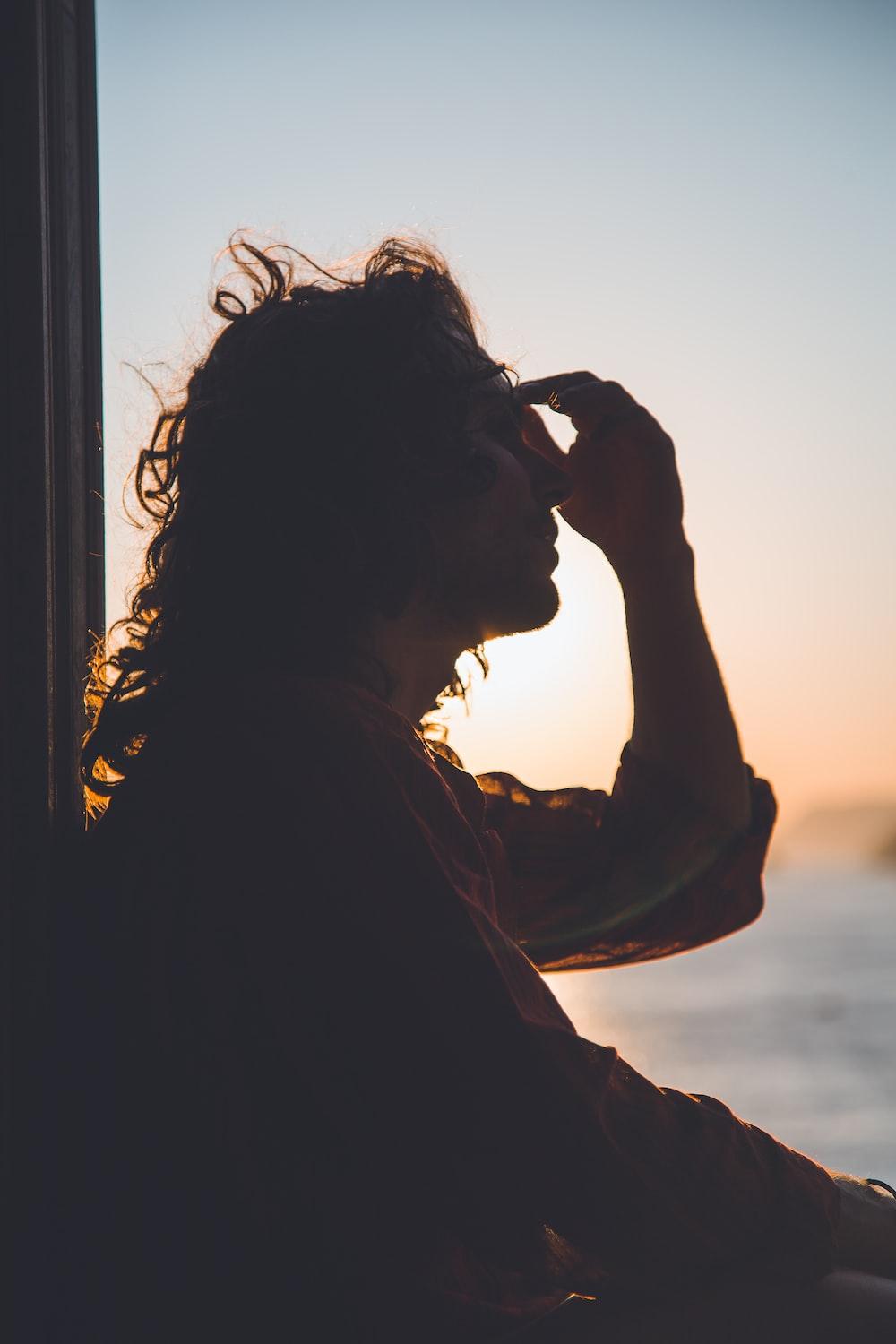 1000x1500 man holding forehead under sunset photo