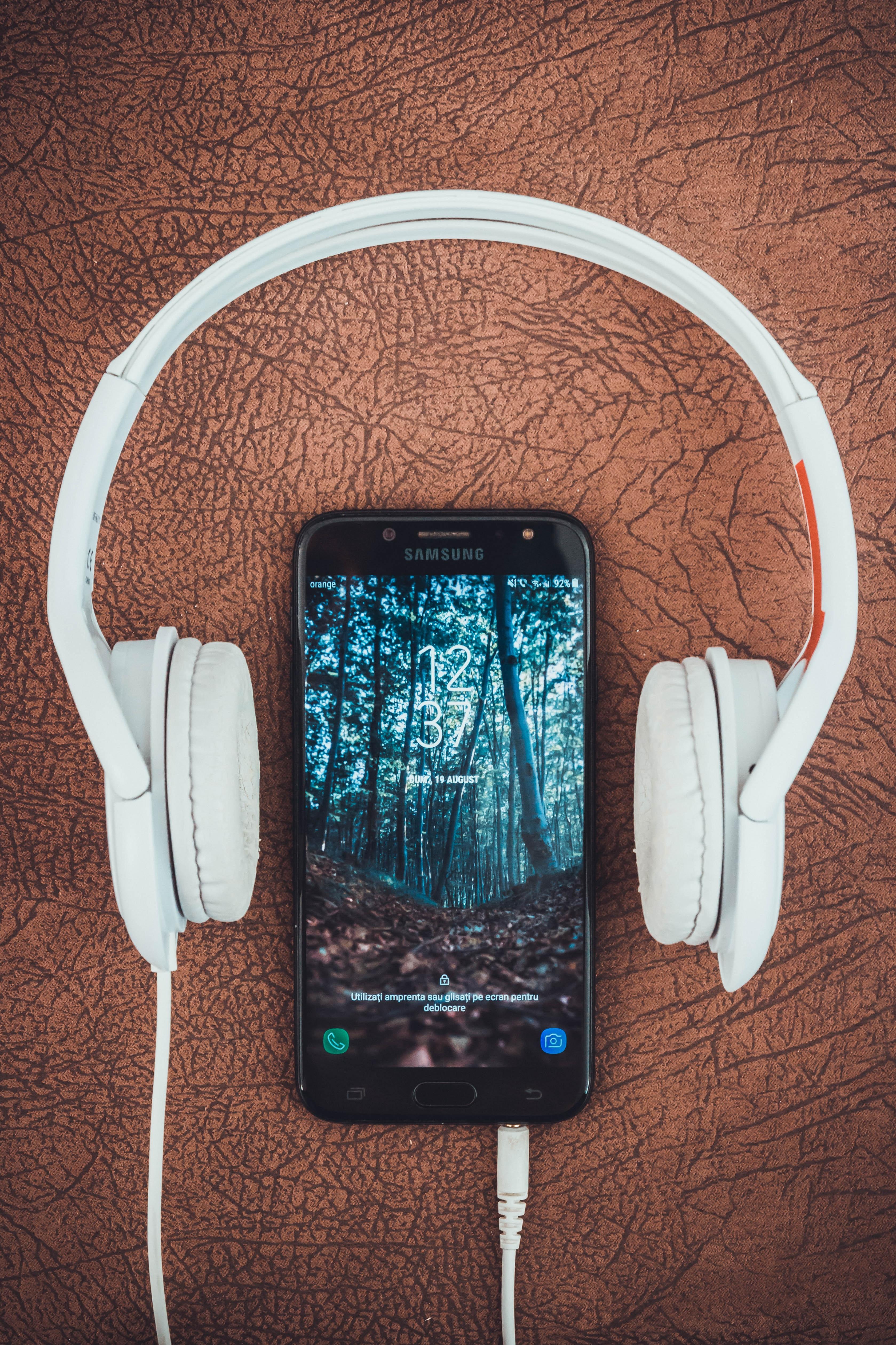 3358x5037 Turned On Black Samsung Smartphone Between Headphones · Free