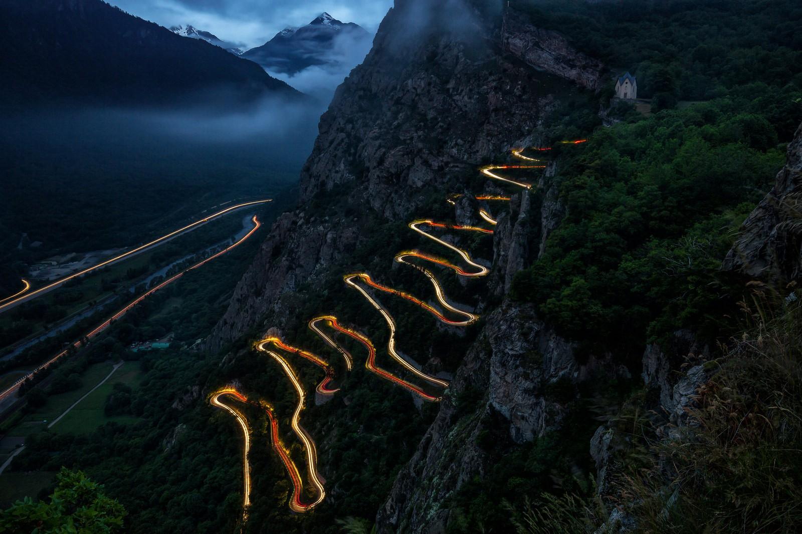 1600x1066 landscape, lights, long exposure, mountains, France, valley, clouds, mist, rocks, hairpin turns, trees, car, road, evening Gallery HD Wallpaper