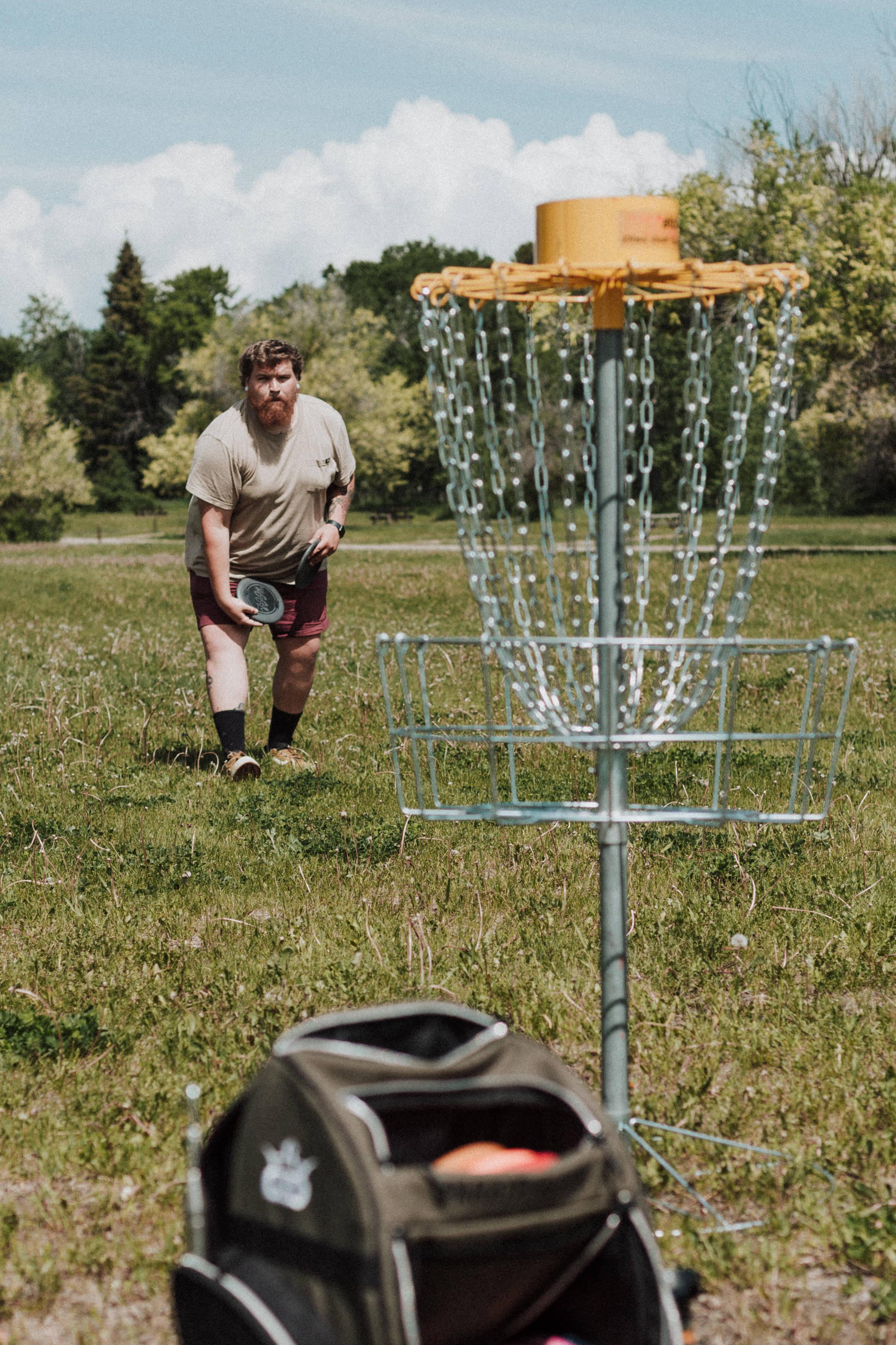 2412x3618 Download Man Playing Frisbee In Park Wallpaper